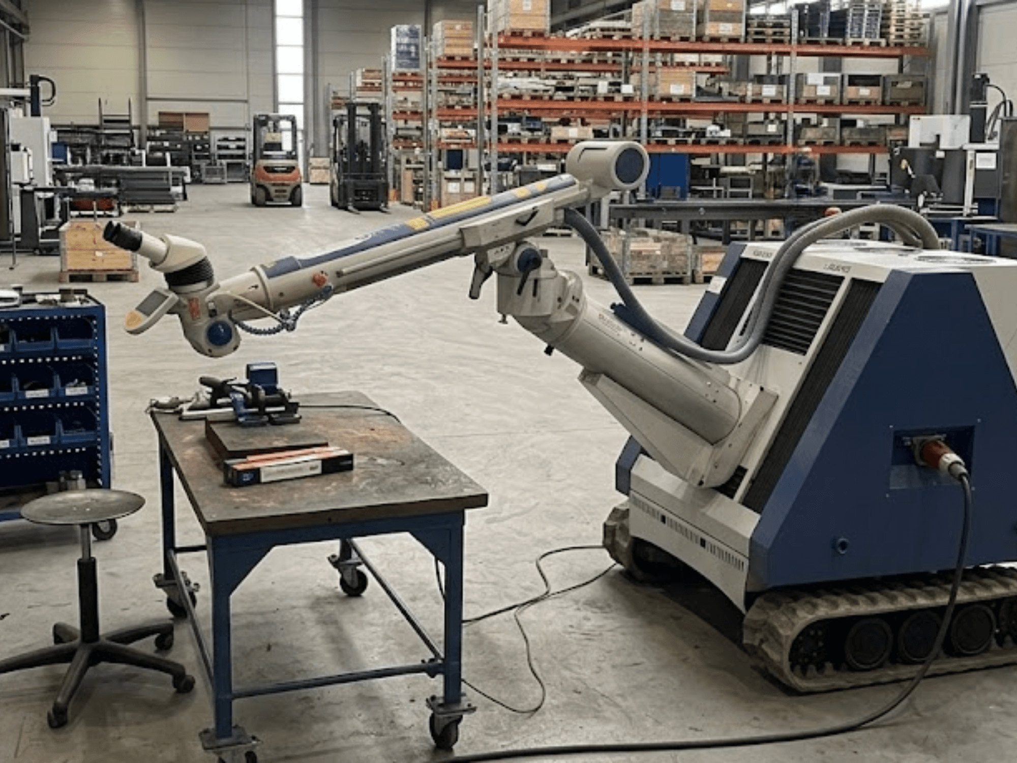 Robotik kol bulunan bir atölyede yer alan ALPHA LASER ALFlak300 M takım tezgahı; iş masası üzerindeki hassas kurulumun görüldüğü önden görünüm.