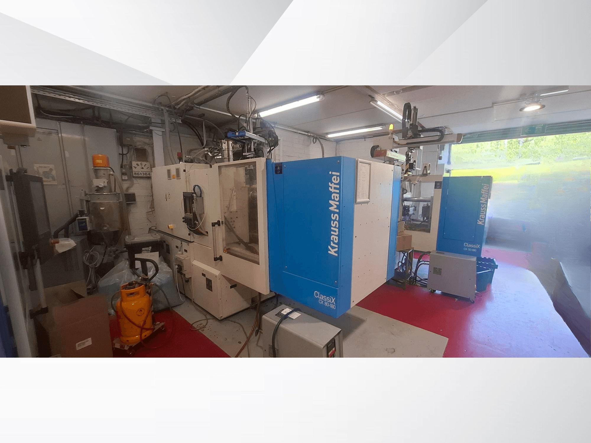 Krauss Maffei CX 80-180 hidrolik enjeksiyon kalıplama makinesi, önden görünüm; makinenin çevresinde çeşitli ekipmanların bulunduğu endüstriyel ortamda.