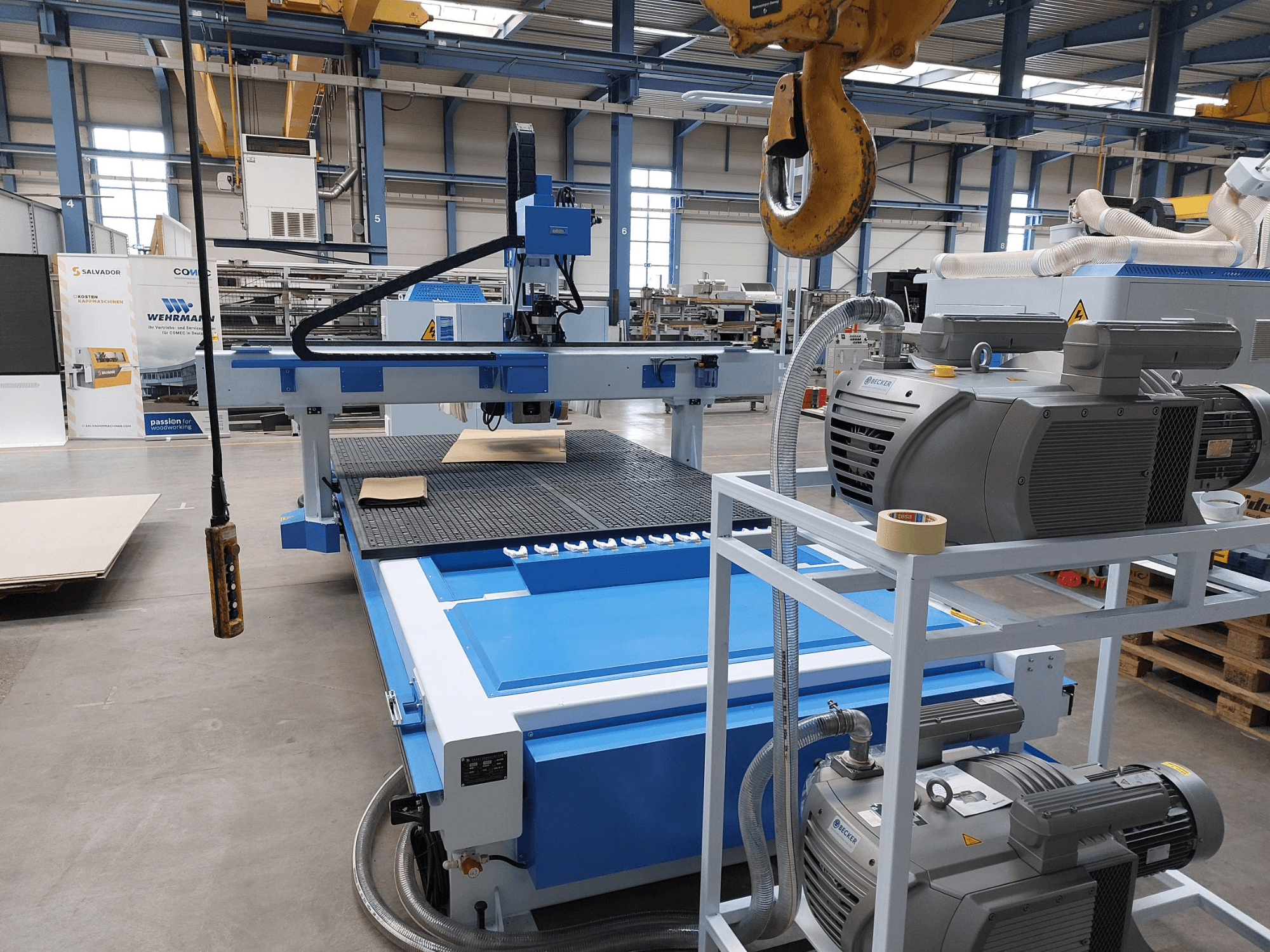 CNC Ağaç İşleme Merkezi QUICK CNC UA 481; kontrol paneli, motorlar ve üzerinde ahşap parça bulunan çalışma yüzeyini gösteren önden görünüm.