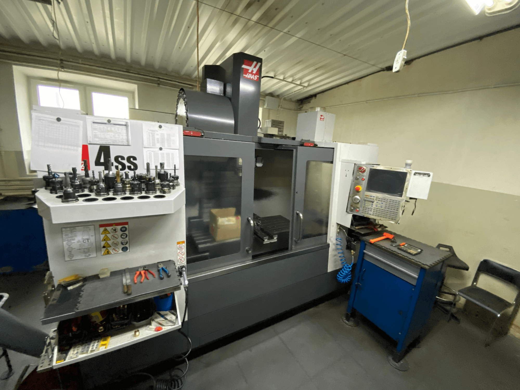 Haas VF-4SS dikey işleme merkezi, takım tutucuları ve kontrol paneli ile ön görünüm. Öne çıkan takımlar ve çalışma alanı görülebilir.