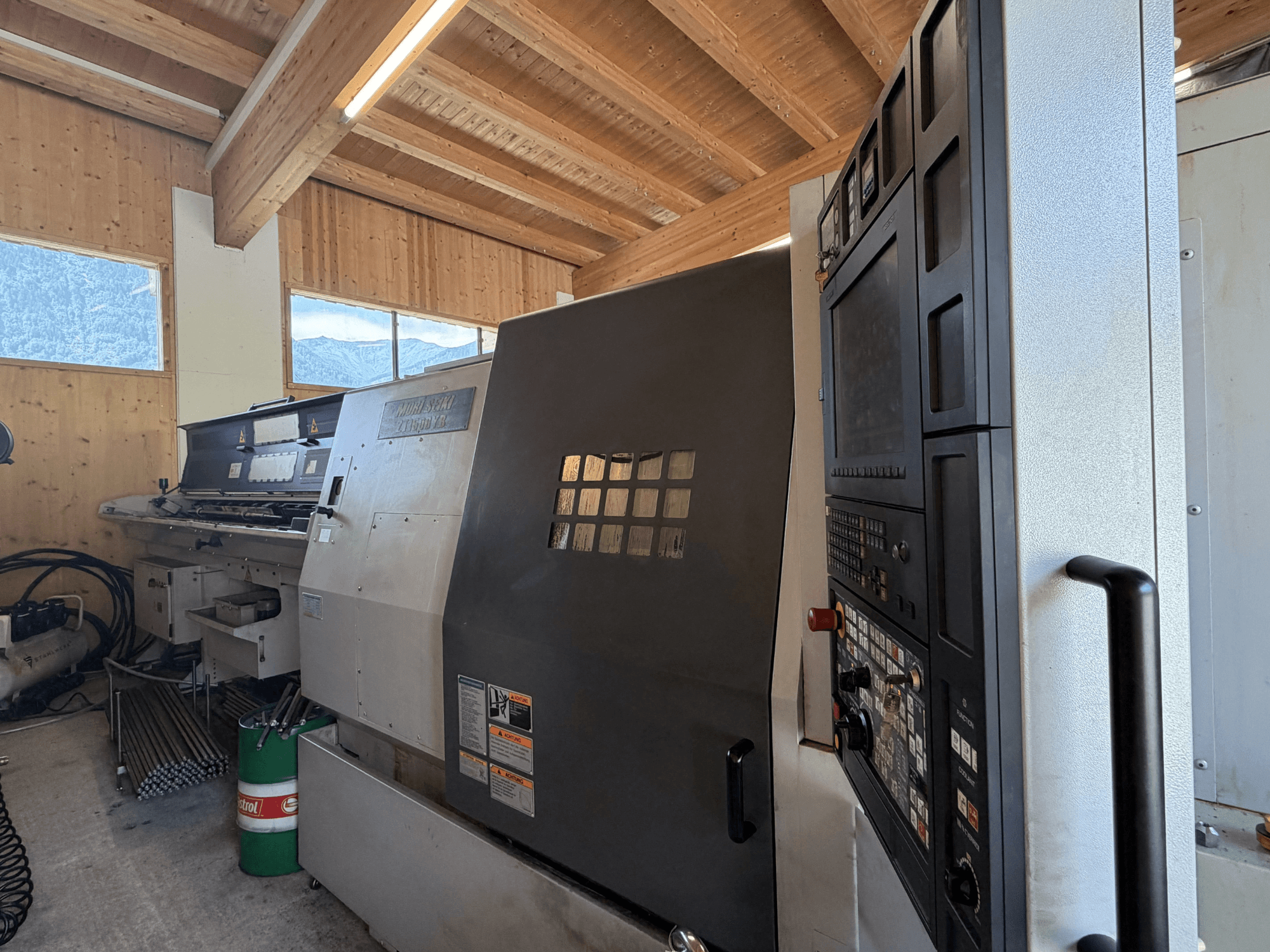 Bir atölyede bulunan MORI SEIKI ZT1500YB torna-freze merkezi; kontrol paneli ve makine özelliklerini gösteren yandan görünüm.