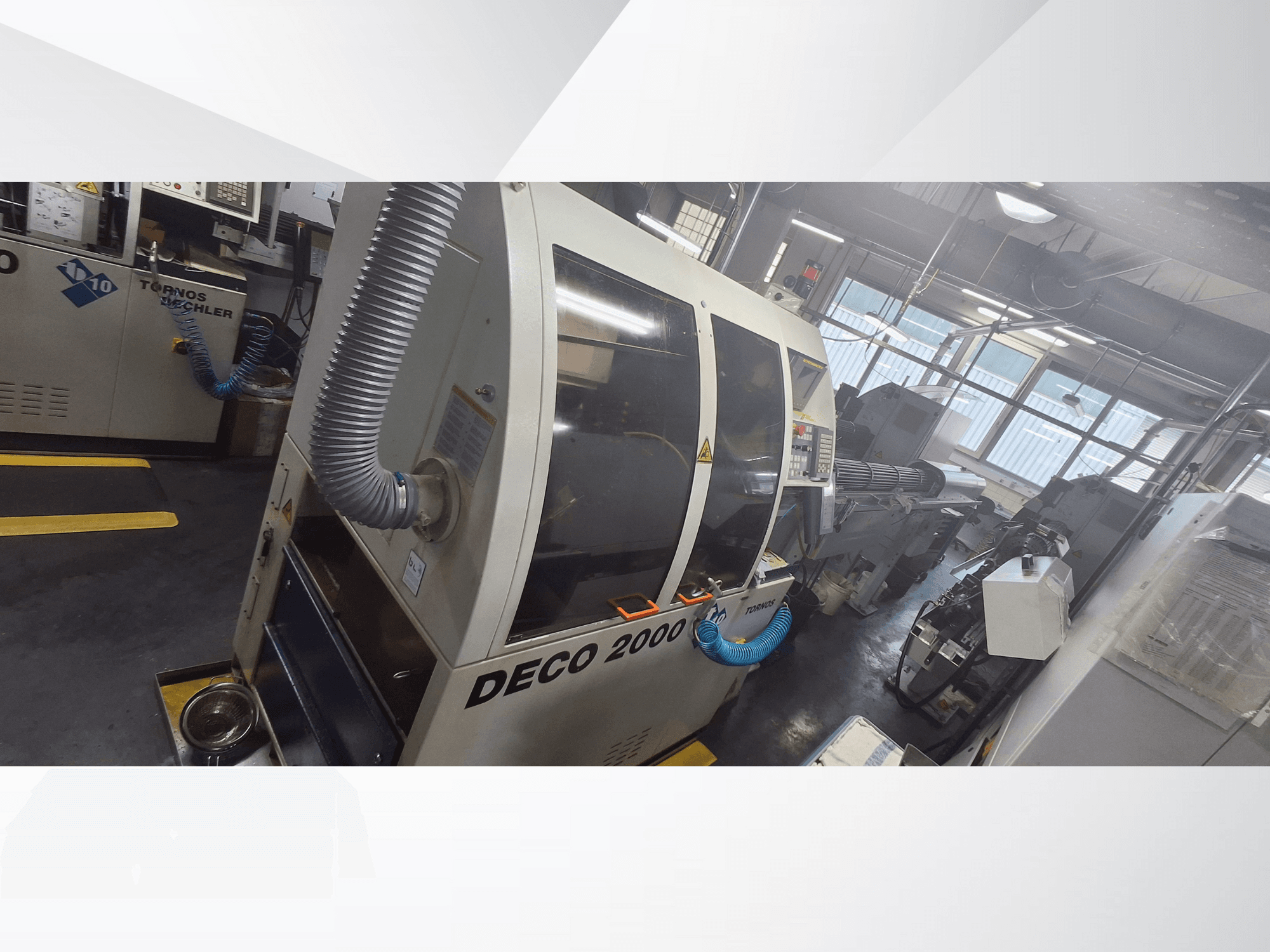 Atölyede DECO 2000 CNC makinesi, önden görünüm, havalandırma hortumu ve kontrol paneli, hassas işleme için tasarlanmıştır.