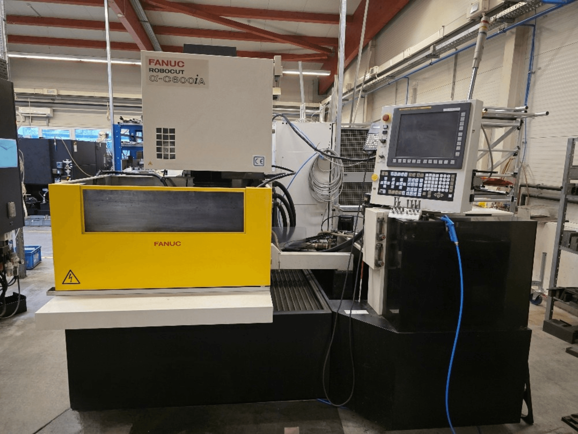 FANUC Robocut α-C600iA tel kesme makinesi, önden görünüm, sarı kontrol paneli ve dijital ekran.