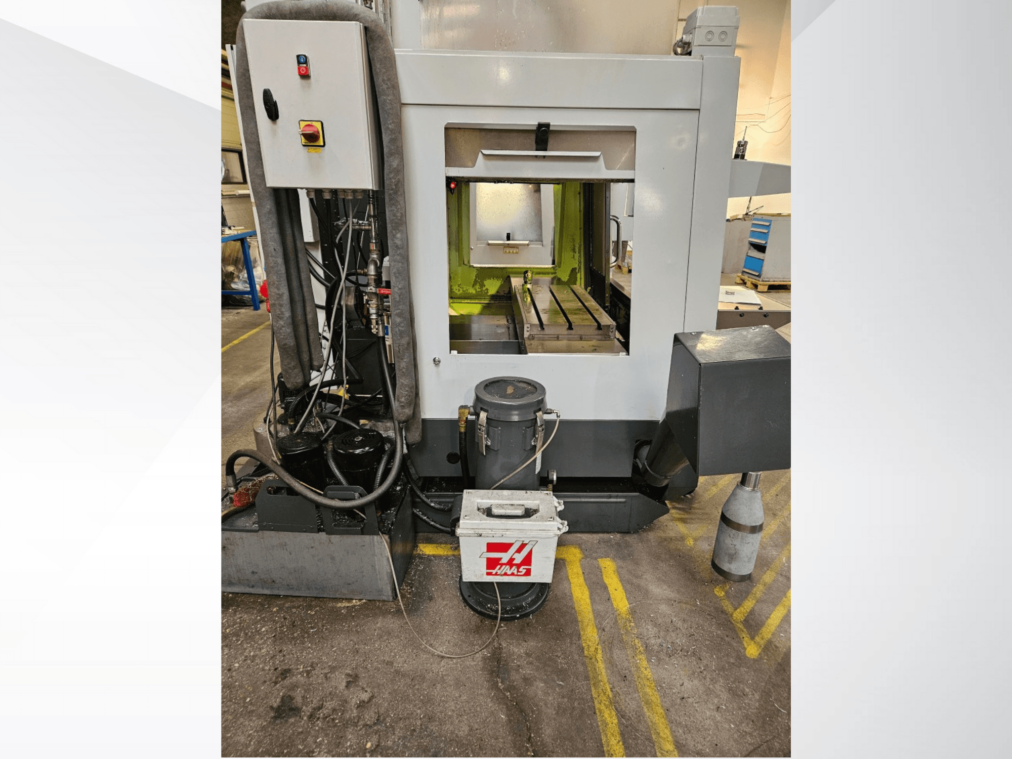 Haas CNC makinesinin önden görünümü; kontrol paneli, soğutma sıvısı tankı ve işlenmiş yatak sergileniyor.