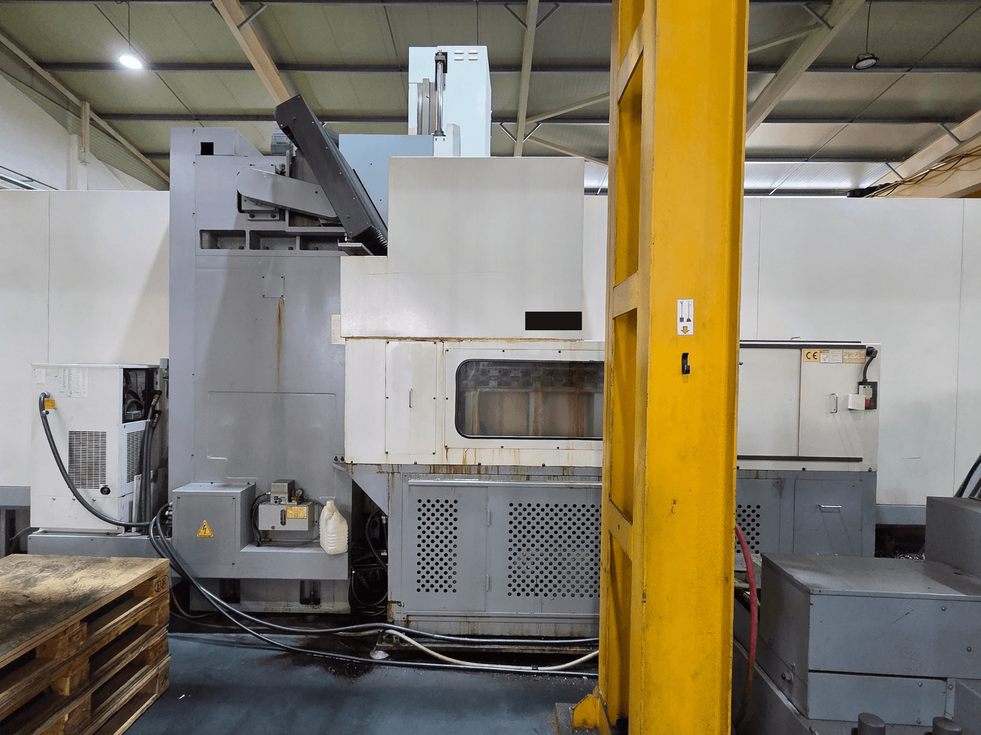 Atölyedeki HARTFORD HB 3150/S dik işleme merkezi, makine gövdesini ve bağlı bileşenleri gösteren yandan görünüm.