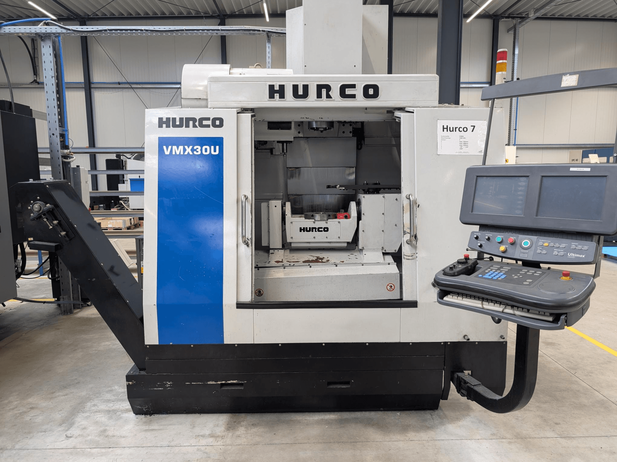 Hurco VMX30U CNC makinesi kontrol paneli ile önden görünümde; geniş bir iç mekan ve hassas kontrol arayüzüne sahiptir.