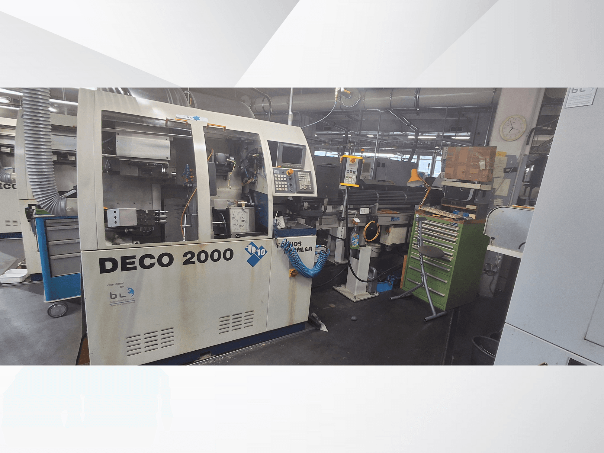 DECO 2000 makinesine önden bakıldığında kontrol paneli, borular ve alet ve kutularla dolu dağınık bir çalışma alanı görülmektedir.