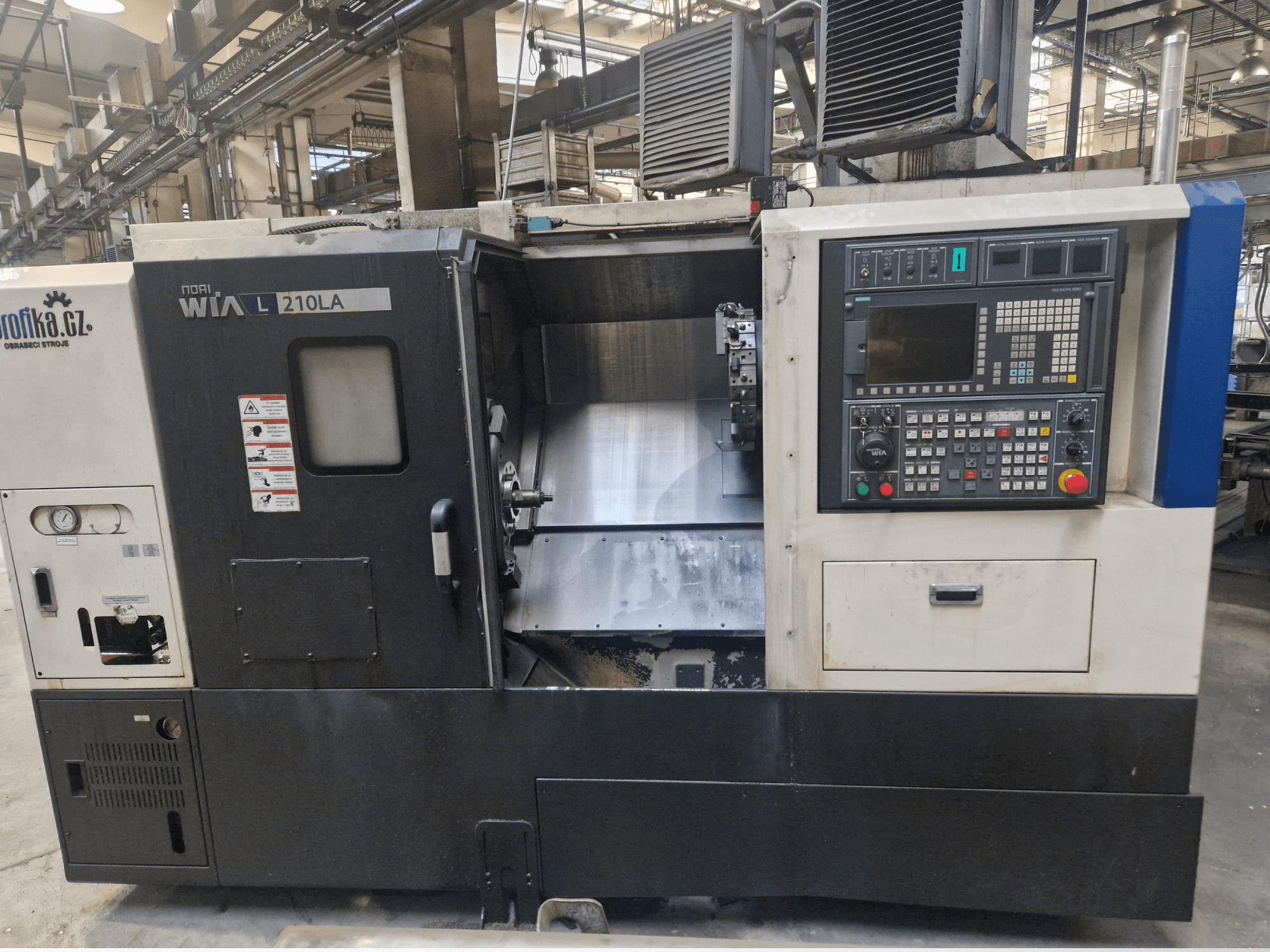 WIA L210LA CNC torna makinesi, önden görünüm, düğmeli kontrol paneli, ekran ve görünür bir işleme alanı içerir.