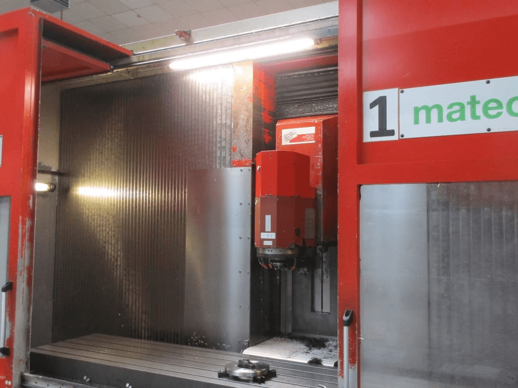 Matec 30 HV CNC Dik İşleme Merkezinin önden görünümü, görünür kesici takım, metal yüzey ve makine iç detayları.