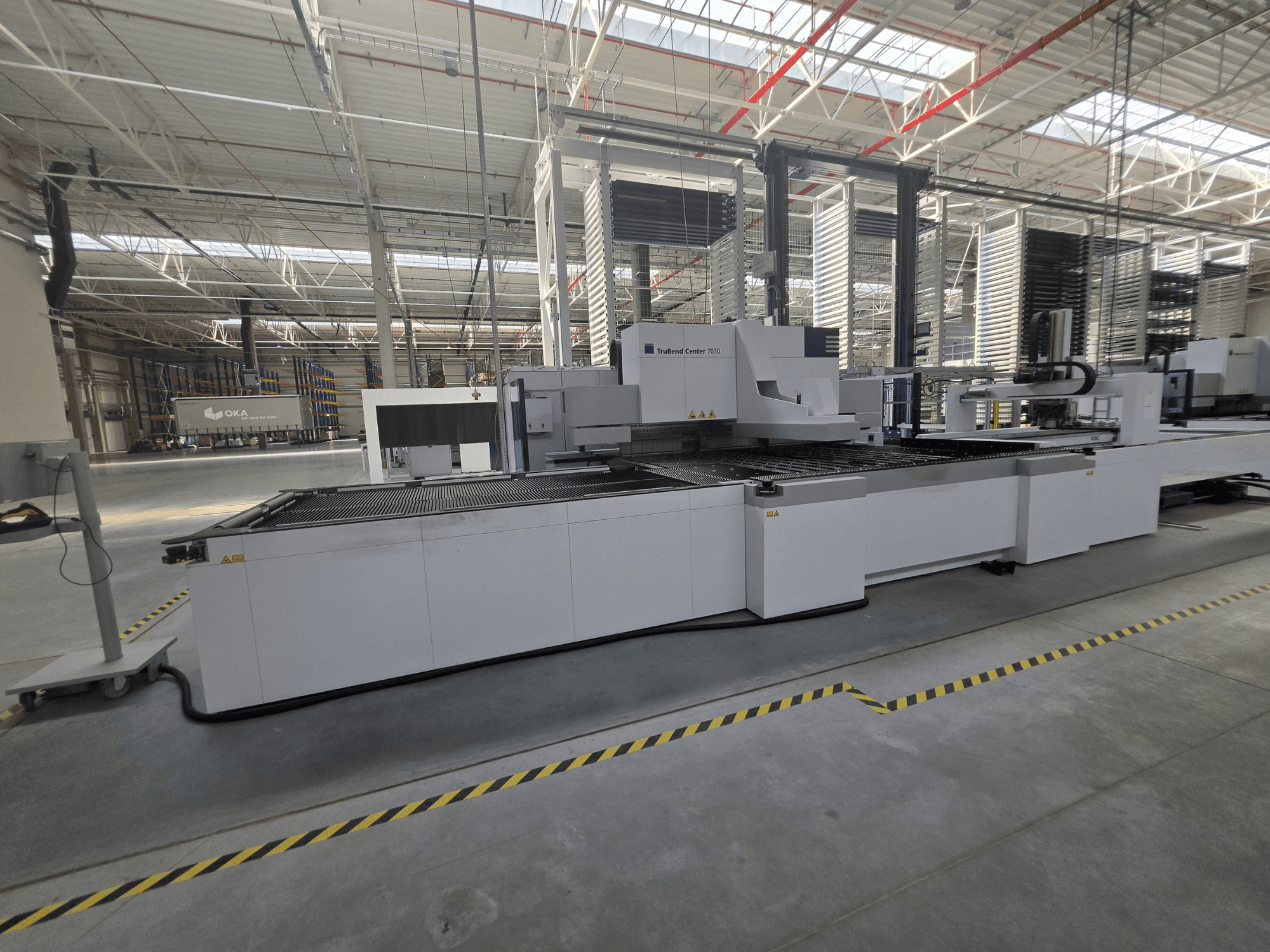 TRUMPF TruBend Center 7030 bükme makinesi, yan görünüm; geniş bir atölyede çalışma alanı ve kumanda panelleri gösterilmektedir.