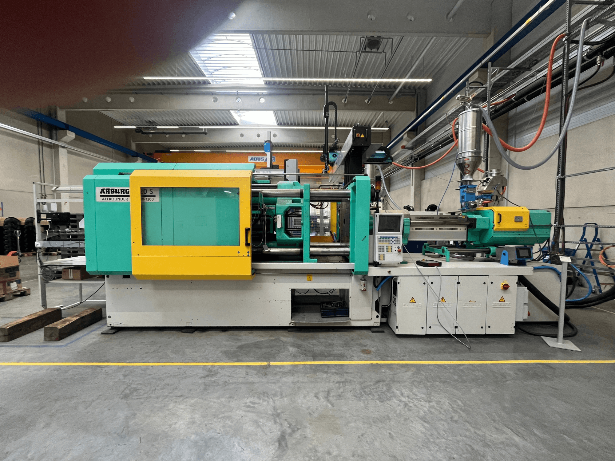 ARBURG Allrounder 370S plastik enjeksiyon kalıplama makinesi, yandan görünüm, yeşil ve sarı kasalı, kontrol arayüzü görünür.