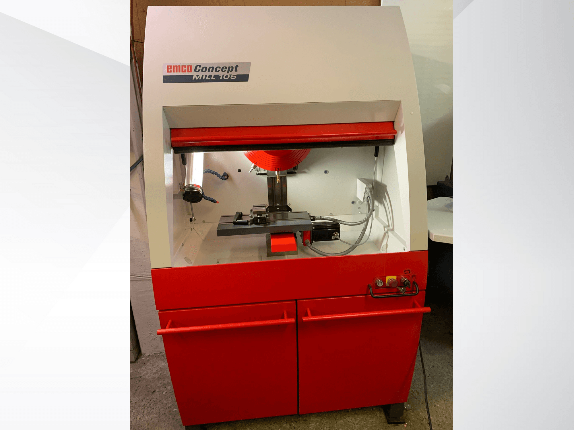 EMCO Concept MILL 105, kırmızı tabanlı, kesici takımlı ve parlak aydınlatmalı kompakt freze makinesinin önden görünümü.