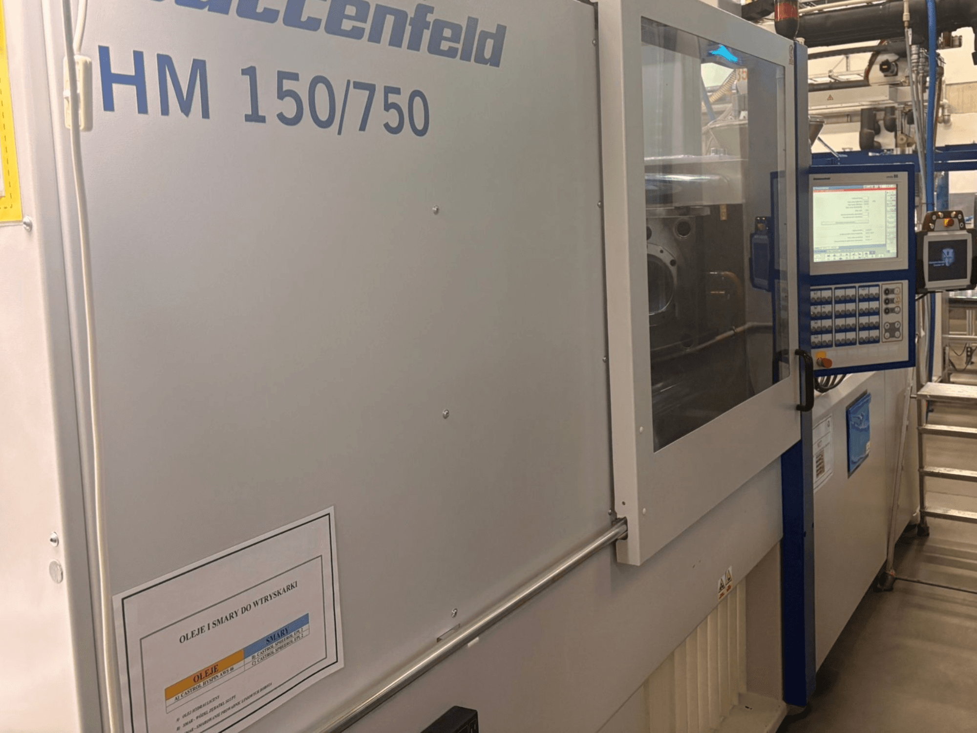 Hoffer Maschinenbau HM 150/750 enjeksiyon kalıplama makinesi, önden görünüm, kontrol panelini ve çalışma ekranını gösterir.