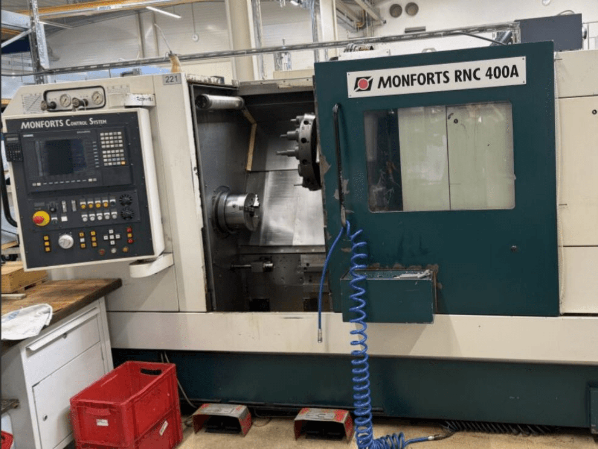 Monforts RNC 400 A yatay torna makinesi, önden görünüm, kontrol paneli ve vurgulanan özelliklerle çalışma alanını gösterir.