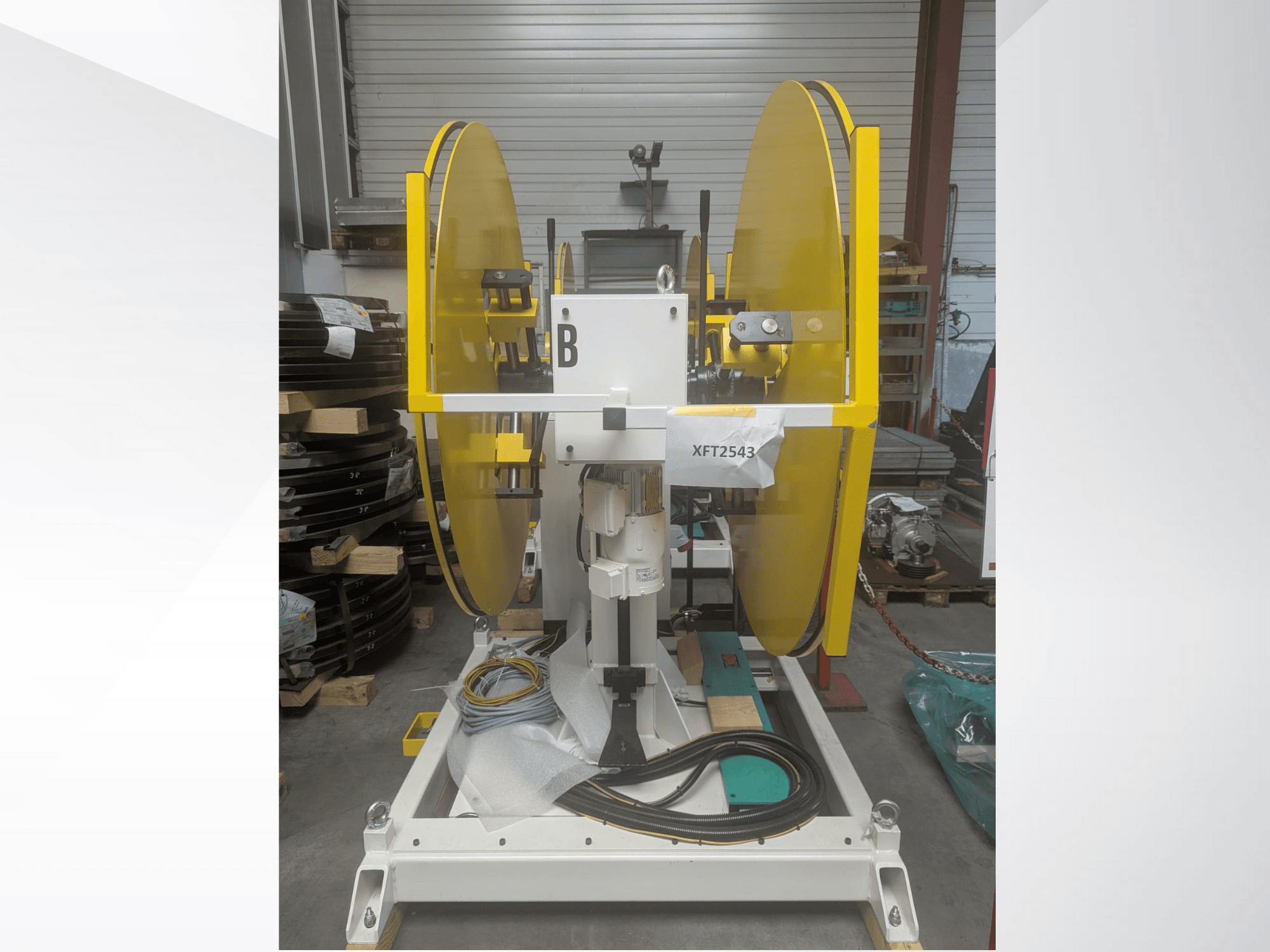 Beyaz bir makine tabanına monte edilmiş sarı daire testere bıçakları, önden görünüm; model XFT2543, görünür kablo ve bileşenlerle birlikte.