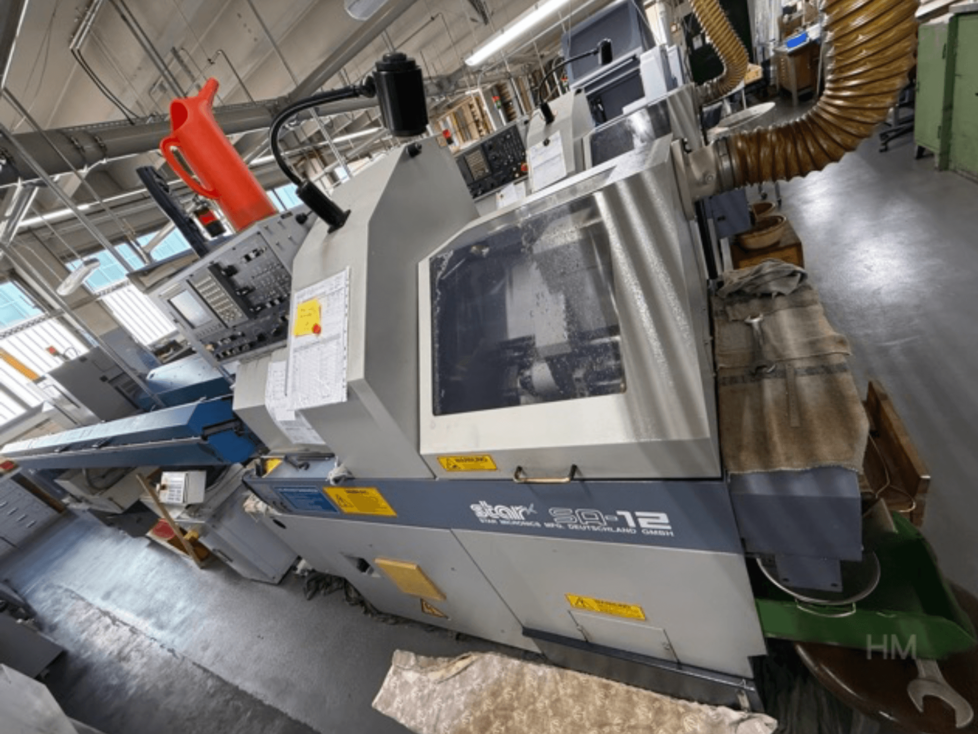 Star SQ-12 işleme merkezi, kontrol paneli, soğutma sıvısı kabı ve toz emme hortumu görünür şekilde yandan görünüm.