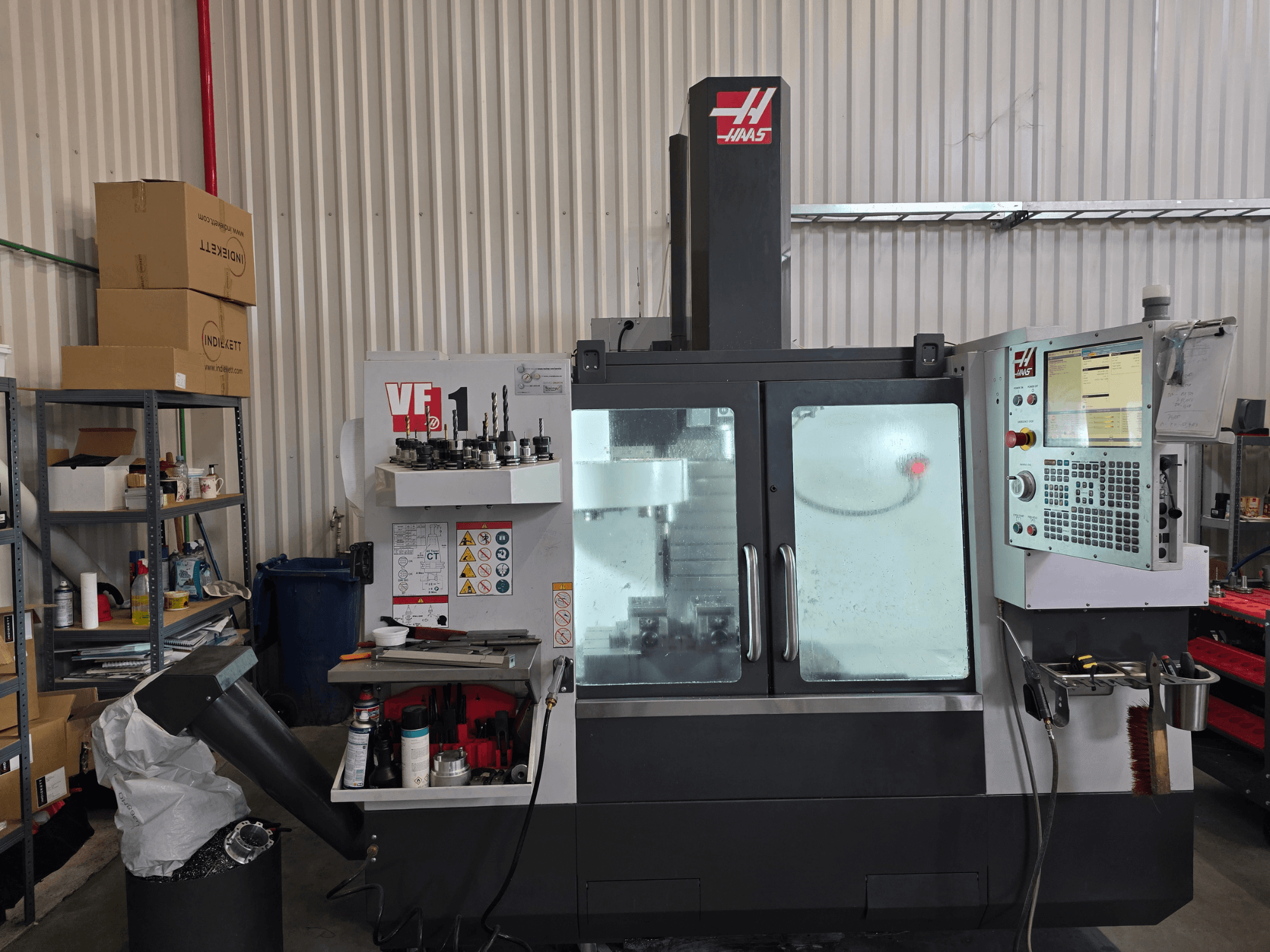 HAAS VF 1 Dik İşleme Merkezi bir atölyede, önden görünümde kontrol paneli ve takımların bulunduğu frezeleme alanı.
