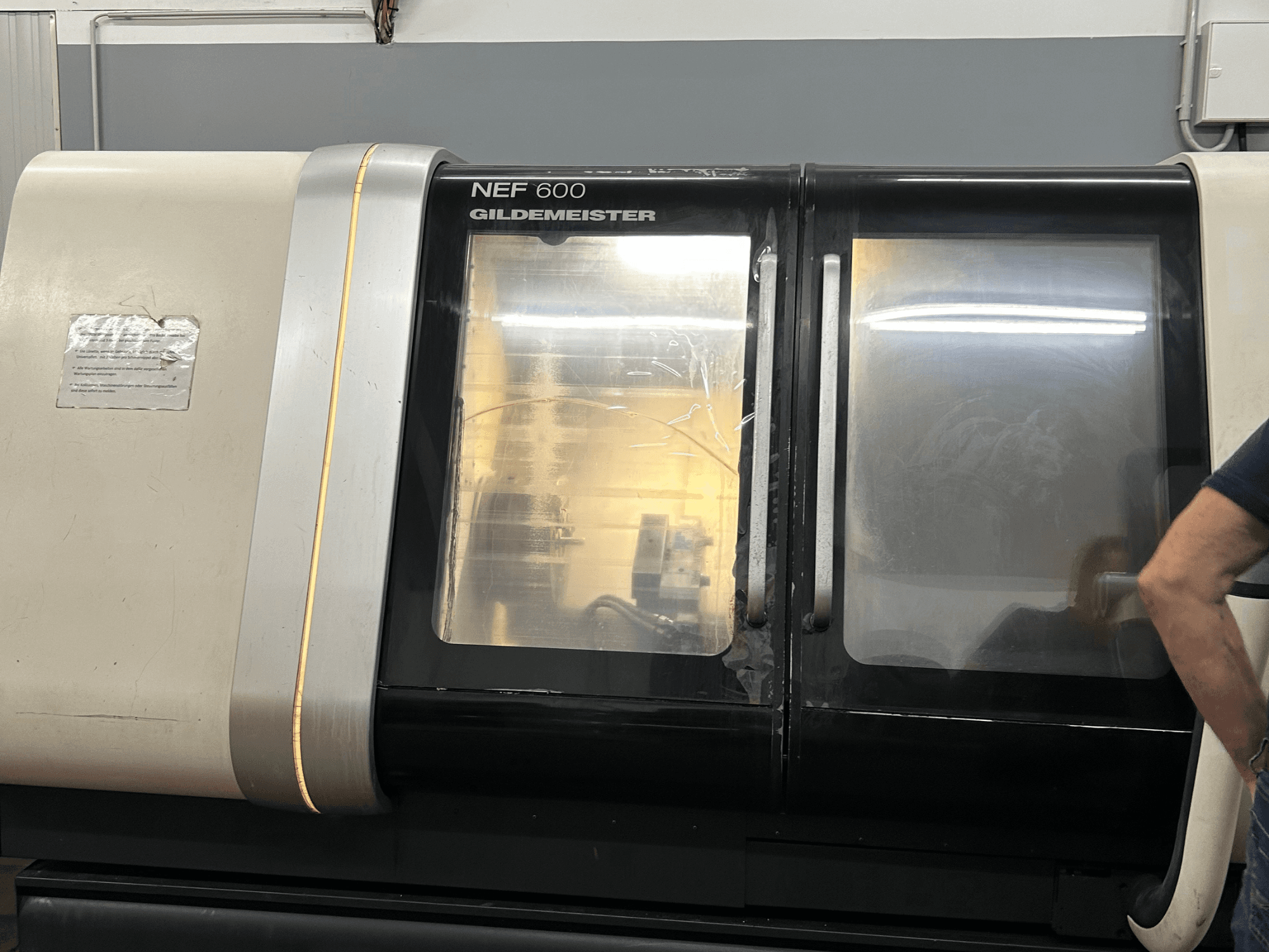Yatay tornalama makinesi DMG NEF 600, önden görünüm, parlak kaplama ve geniş izleme pencereleri.
