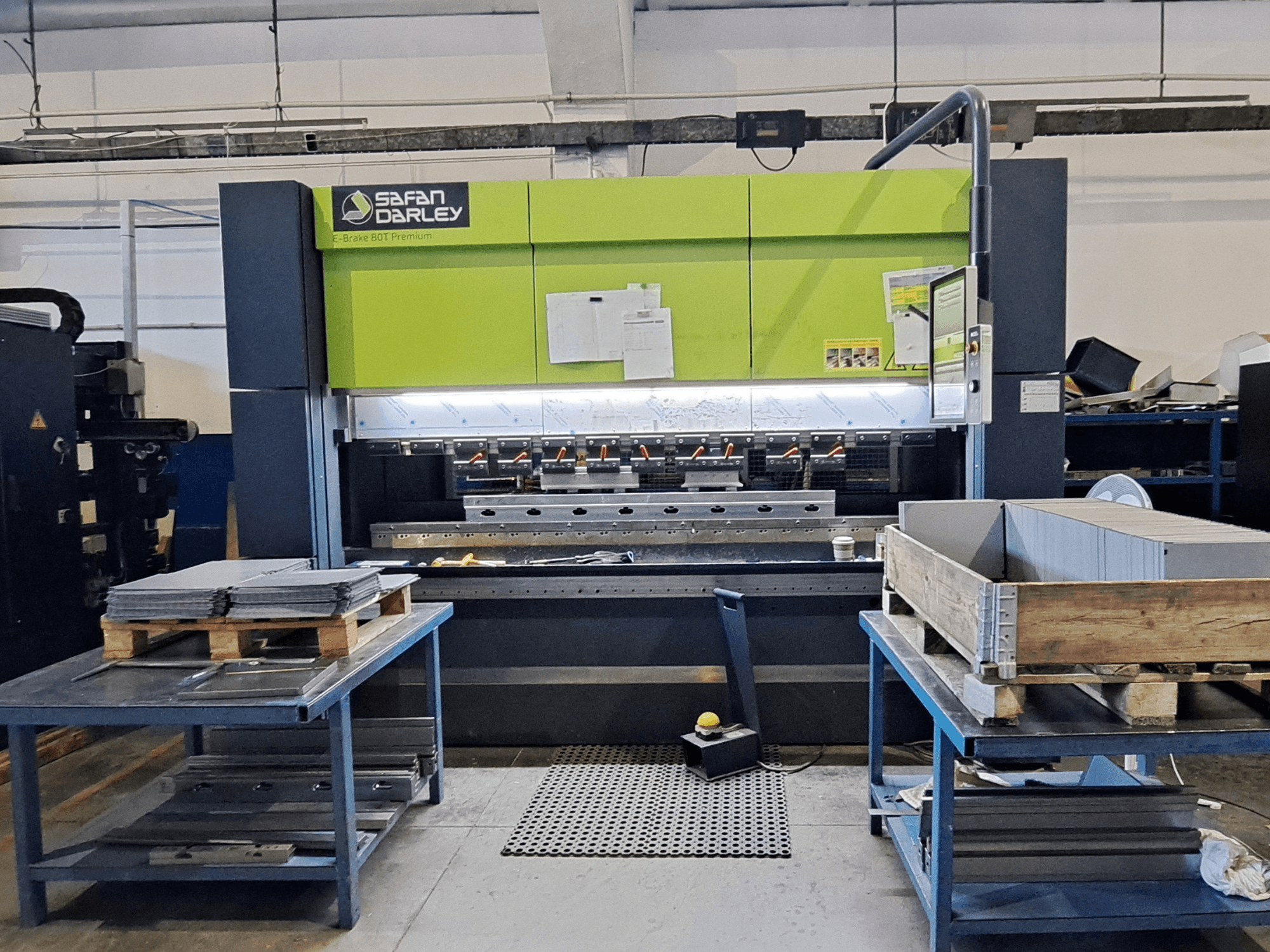 Bir atölyede bulunan SAFAN E-Brake Premium 80-2550 pres fren makinesi; üst üste yığılmış metal levhaların ve kontrol panelinin görüldüğü önden görünüm.