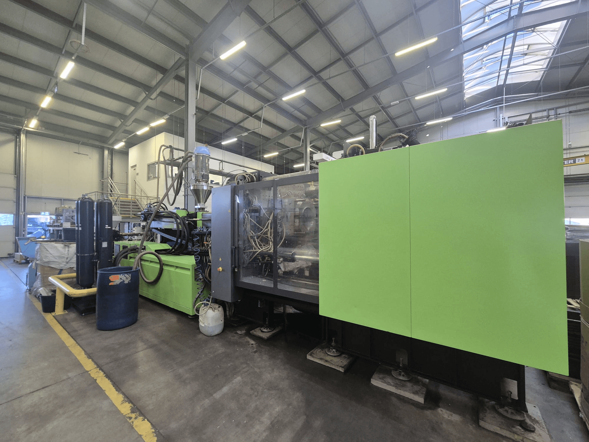 Bir fabrika ortamında, yandan bakıldığında yeşil dış yüzeyi ve bileşenleri görülebilen Engel duo 5160/700 hidrolik enjeksiyon kalıplama makinesi.