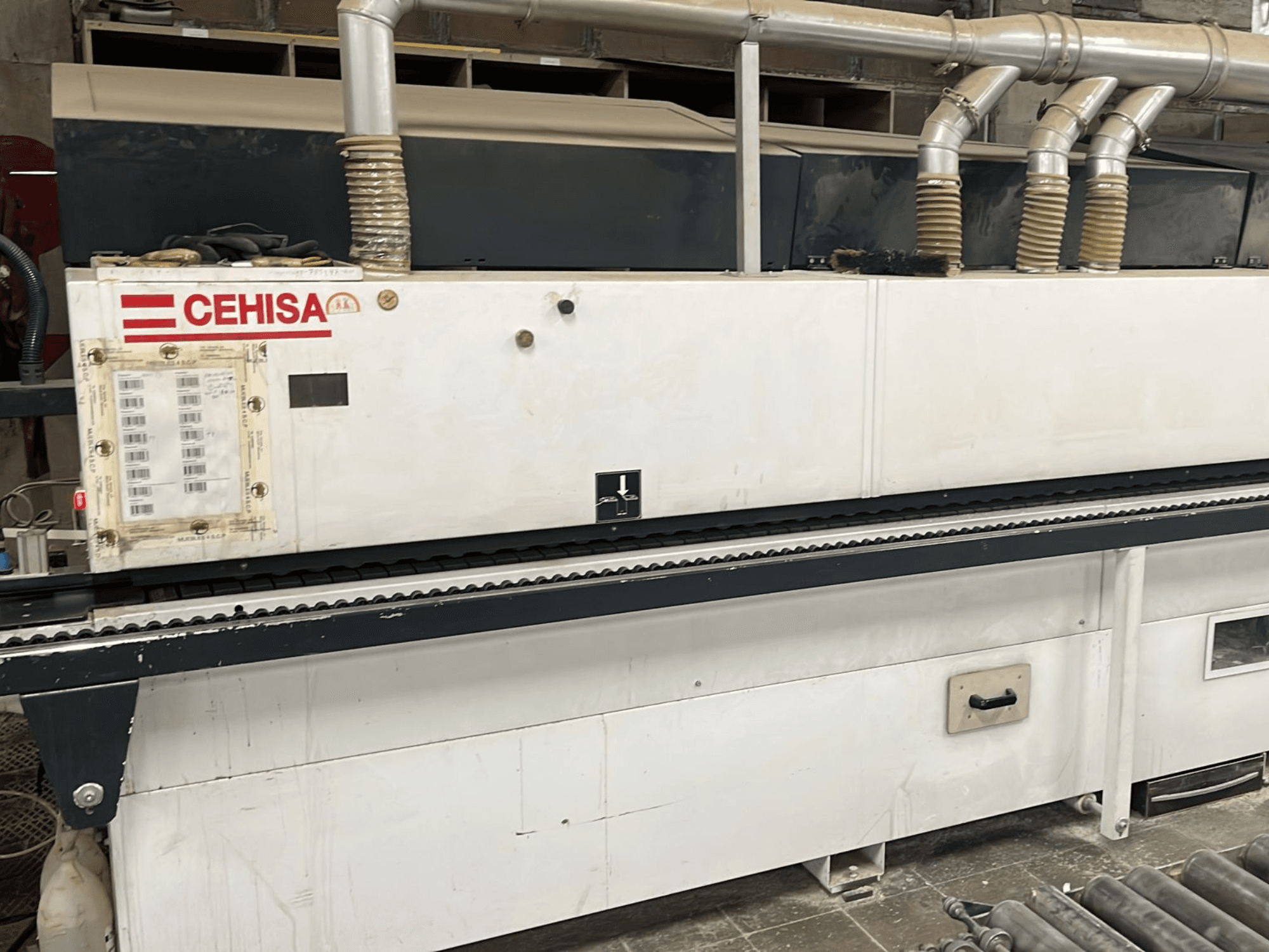 CEHISA PRO 12 CONCEPT kenar kaplama makinesinin önden görünümü; kontrol paneli, toz emme boruları ve konveyör bandı görülmektedir.