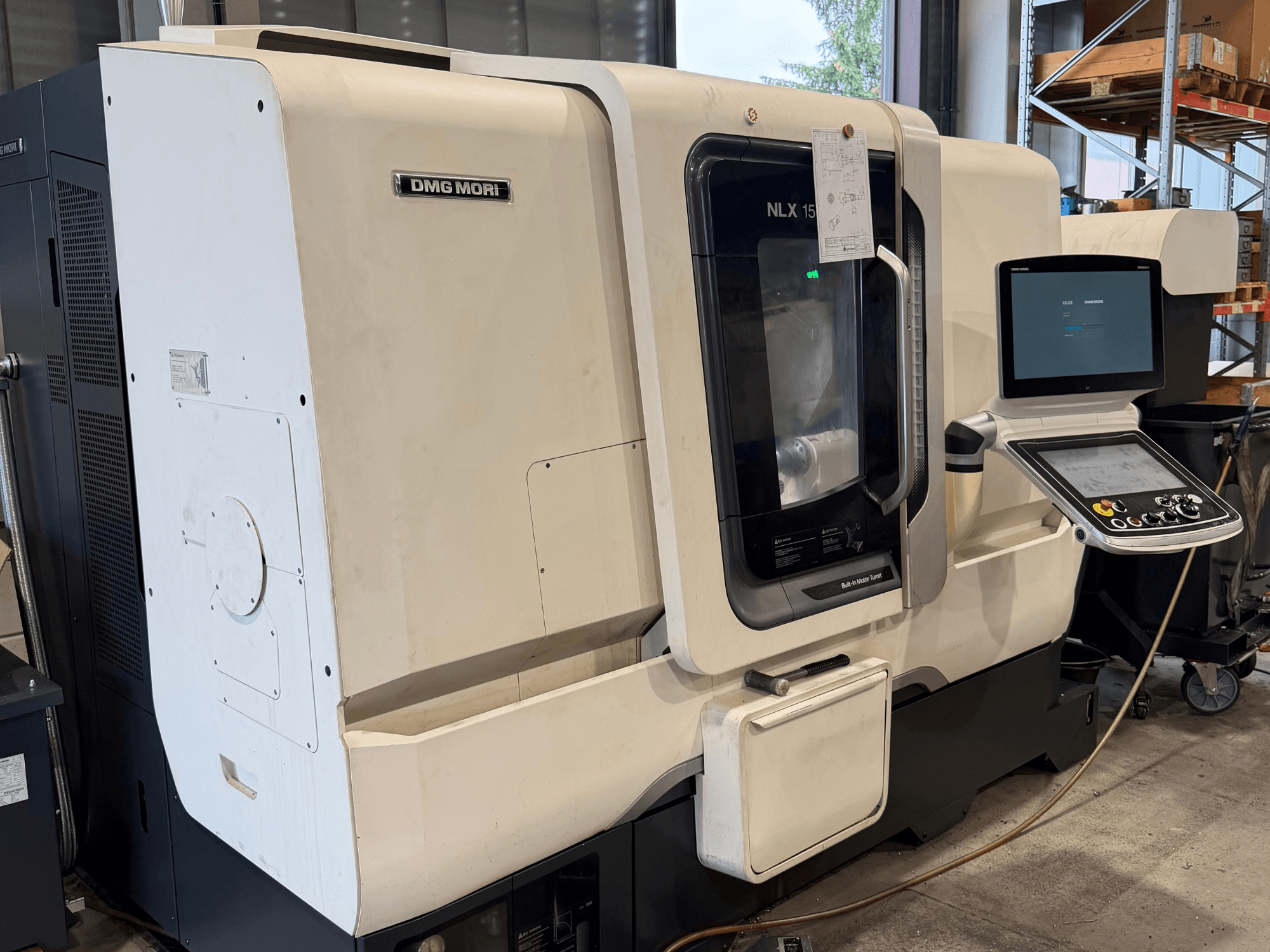 DMG MORI NLX1500MC/500 yatay torna tezgahının önden görünümü; şeffaf kapak aracılığıyla kontrol paneli ve iş mili bölümü görülebilmektedir.