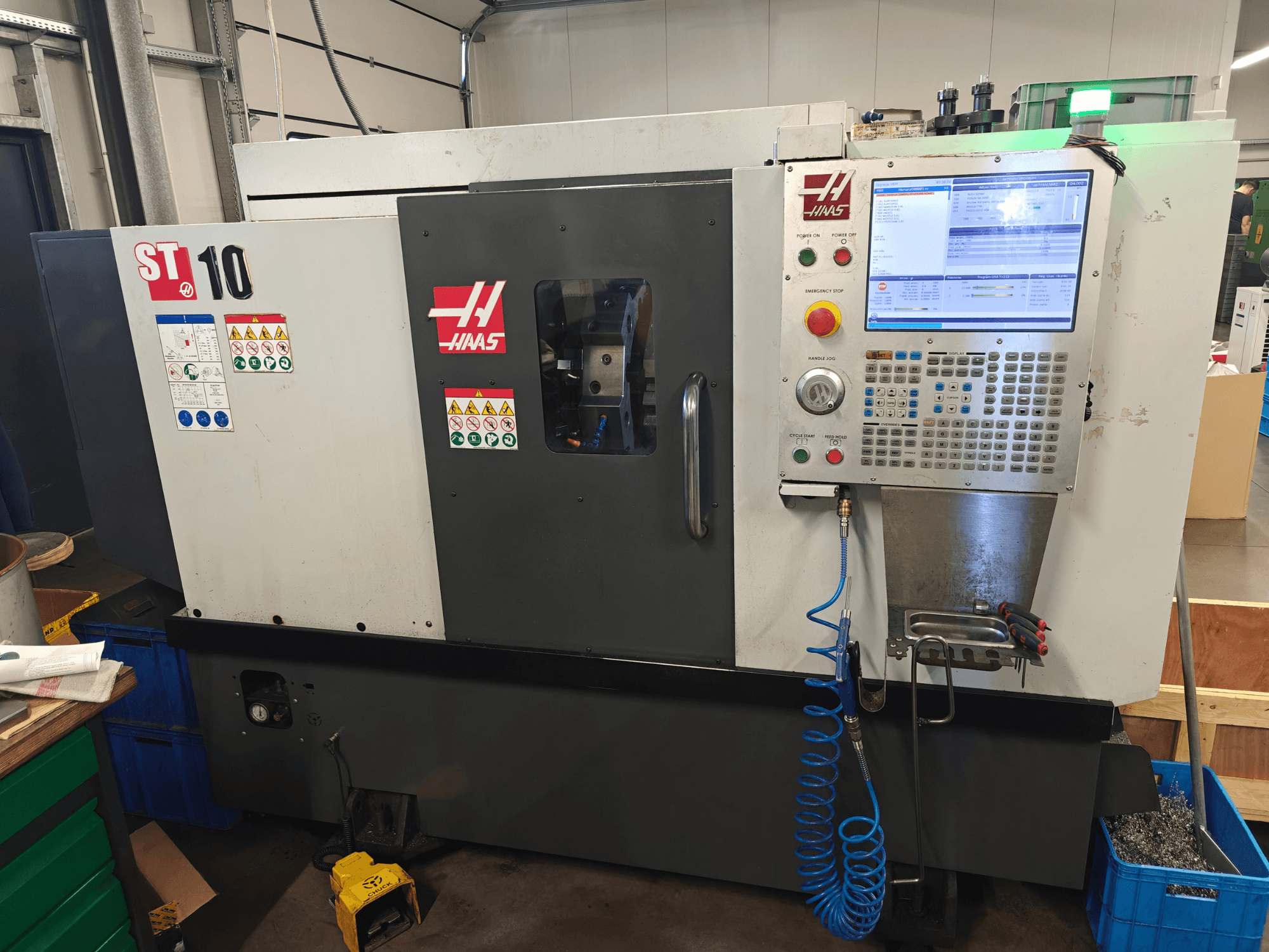 Haas ST-10 yatay torna tezgahı, önden görünüm; kontrol paneli, güvenlik etiketleri ve makine yapısı gösterilmektedir.