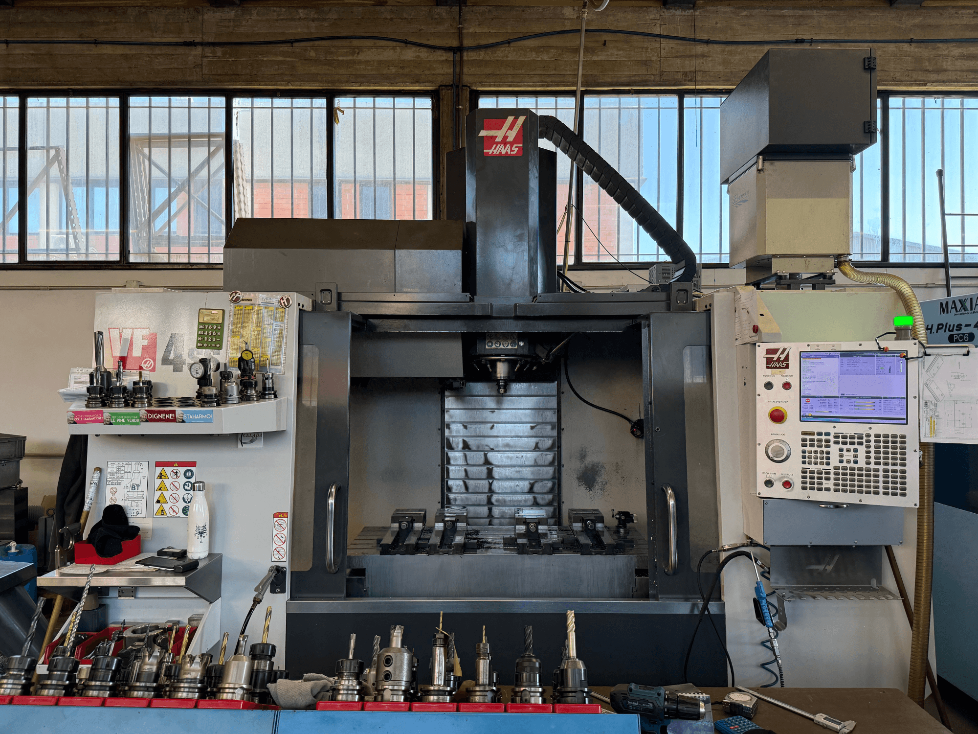 HAAS VF-4SS dikey işleme merkezi, önden görünüm; kontrol paneli, takım tutucular ve iş mili bölgesi açıkça görülmektedir.