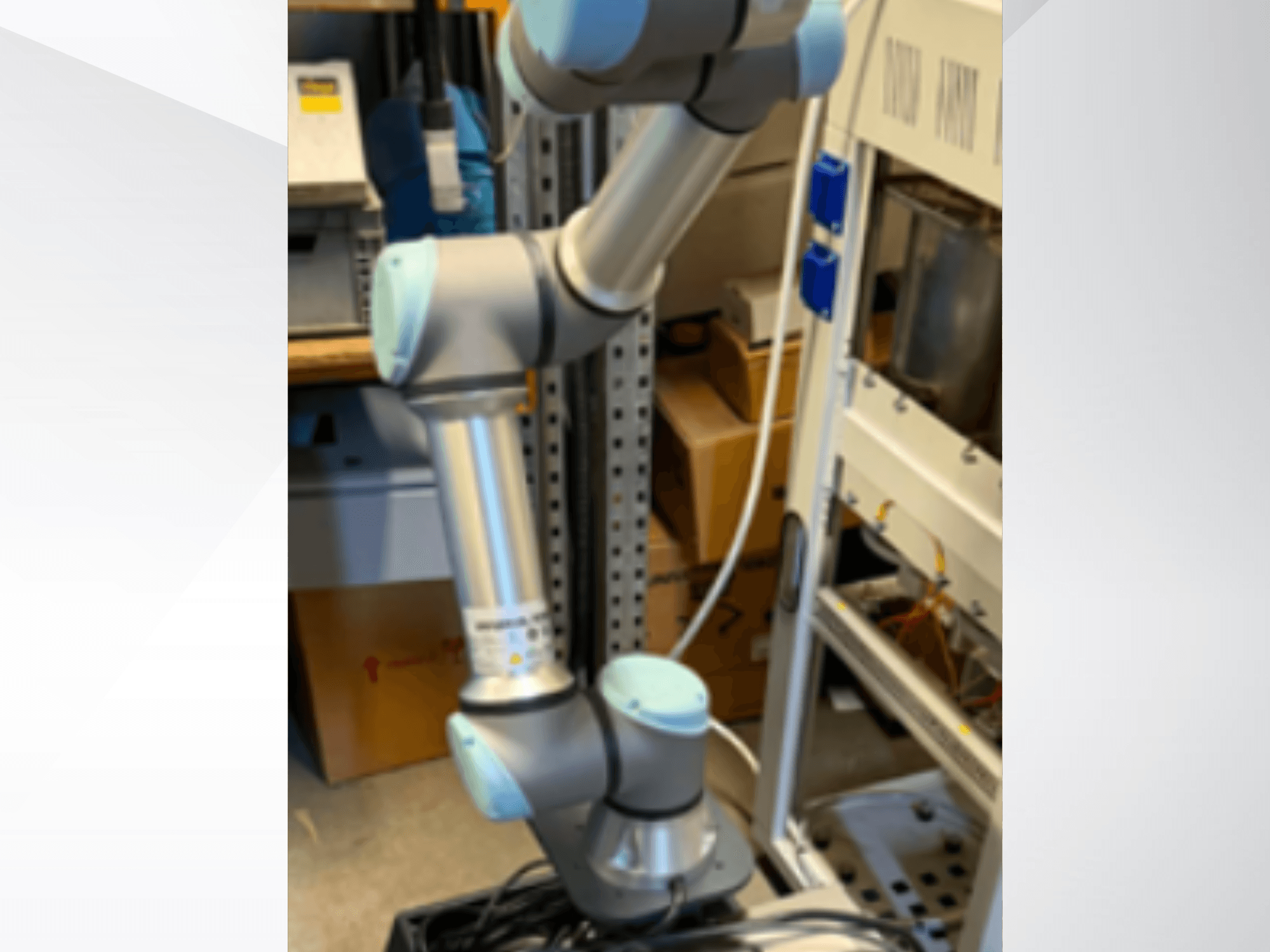 Yandan bakıldığında, mafsallı eklemleri, hafif tasarımı ve kontrol kabloları görülebilen Universal Robots UR5e robot kolu.