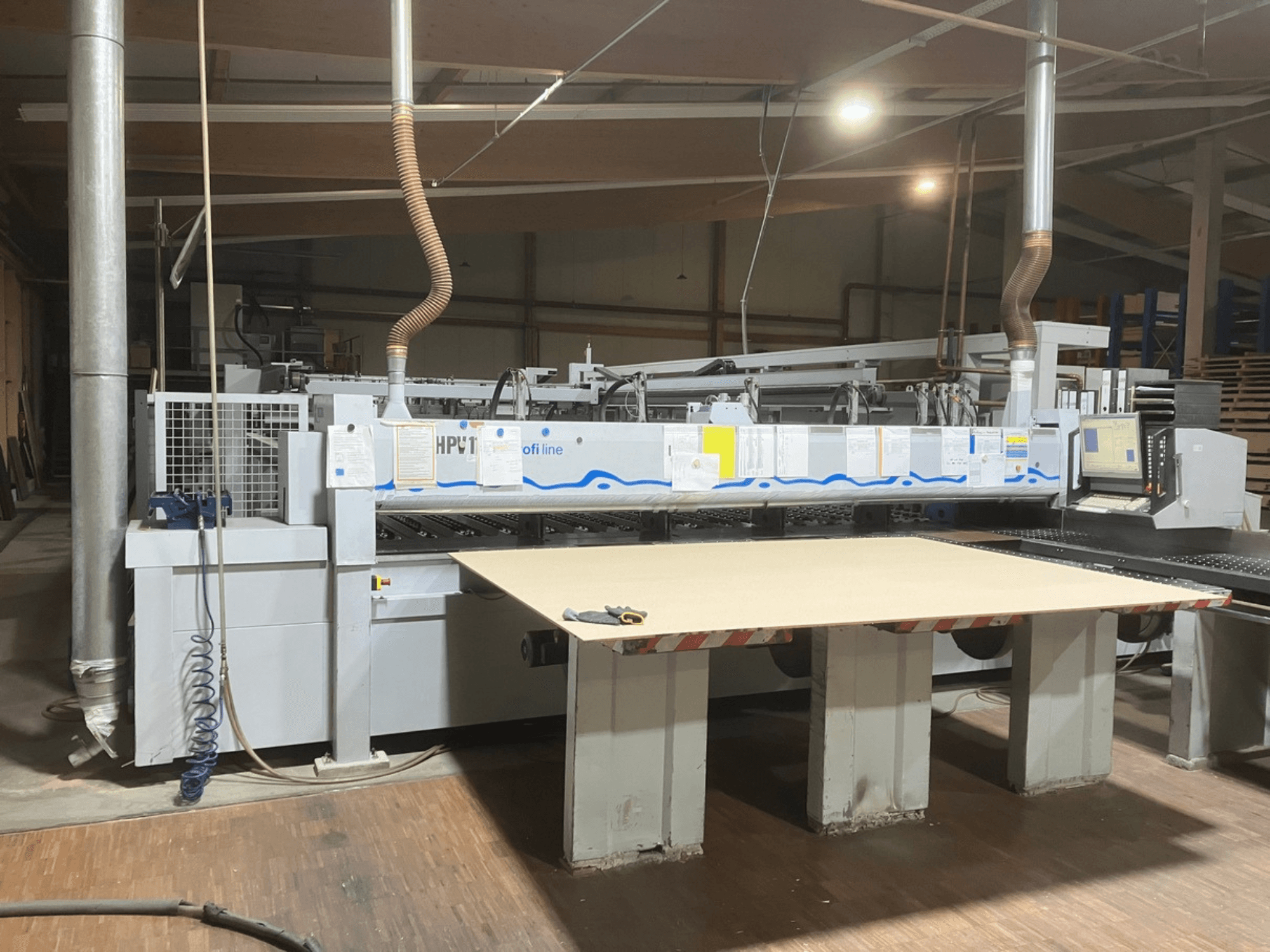 Bir atölyede bulunan HOLZMA HPV11 panel testere; geniş, düz bir çalışma yüzeyi ve kontrol paneli görülebilen önden görünüm.