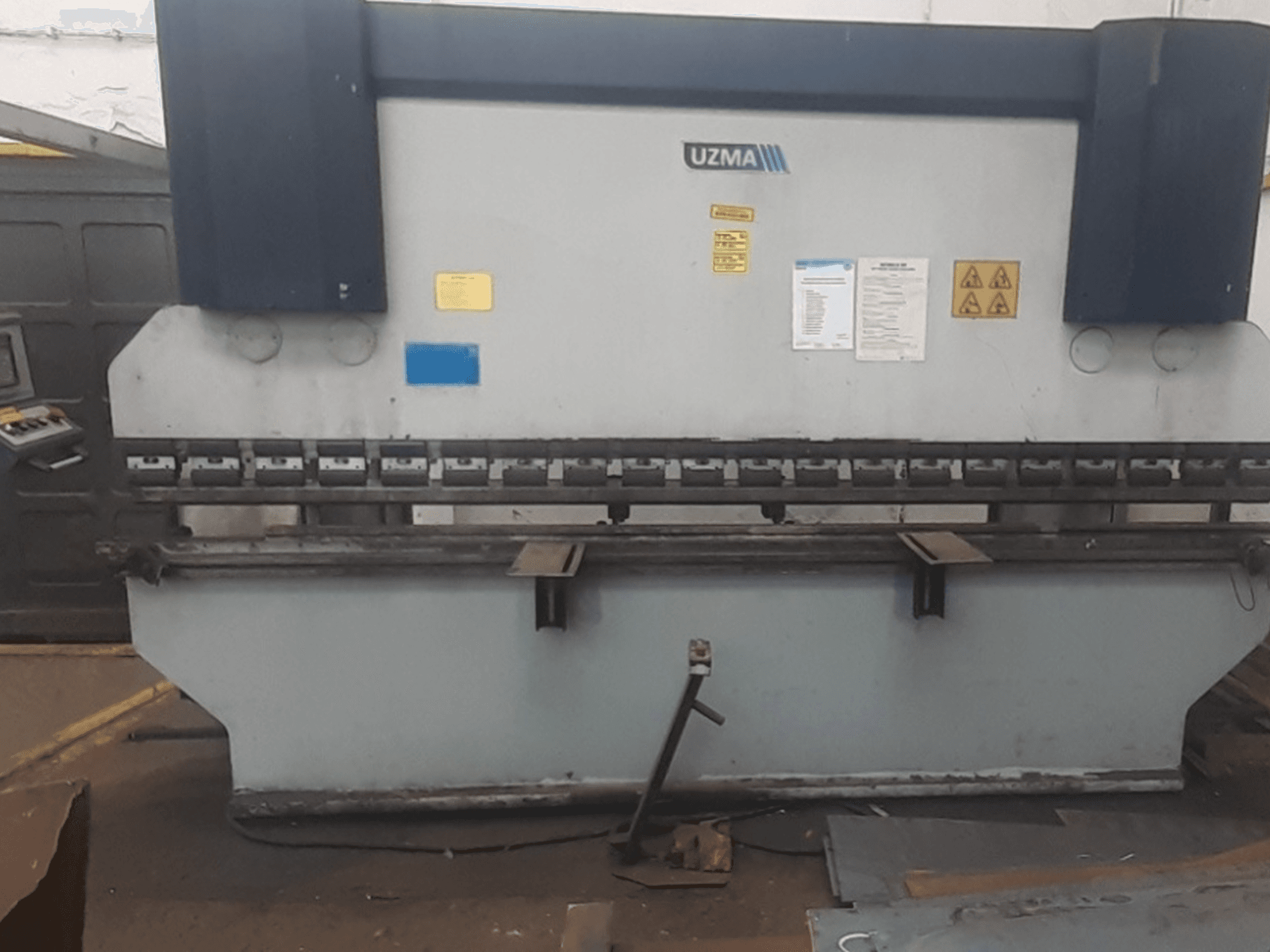 UZMA HAP 40160 abkant presin önden görünümü, kontroller, güvenlik uyarıları ve metal bükme aletleri.