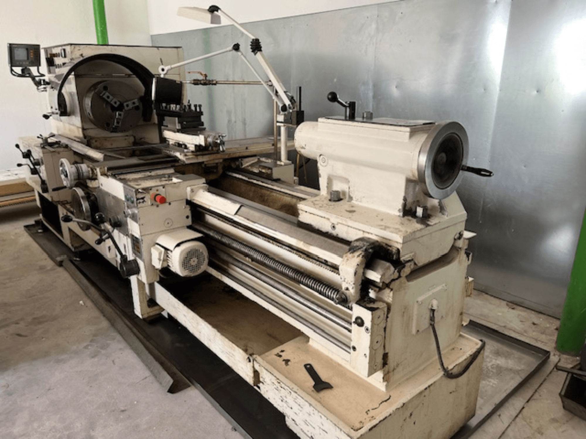 Kontrol paneli ve aletleriyle birlikte vintage metal torna makinesi, yandan görünüm, çalışma elemanlarını ve metal kaplamayı gösterir.