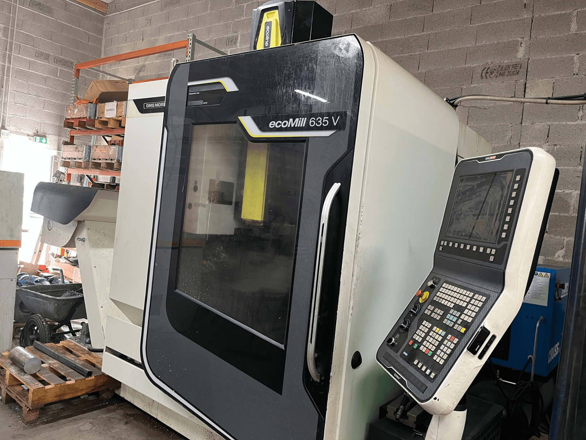 EcoMill 635 V CNC freze makinesi, önden görünüm, endüstriyel çalışma alanında bulunan düğmeli kontrol paneline sahiptir.