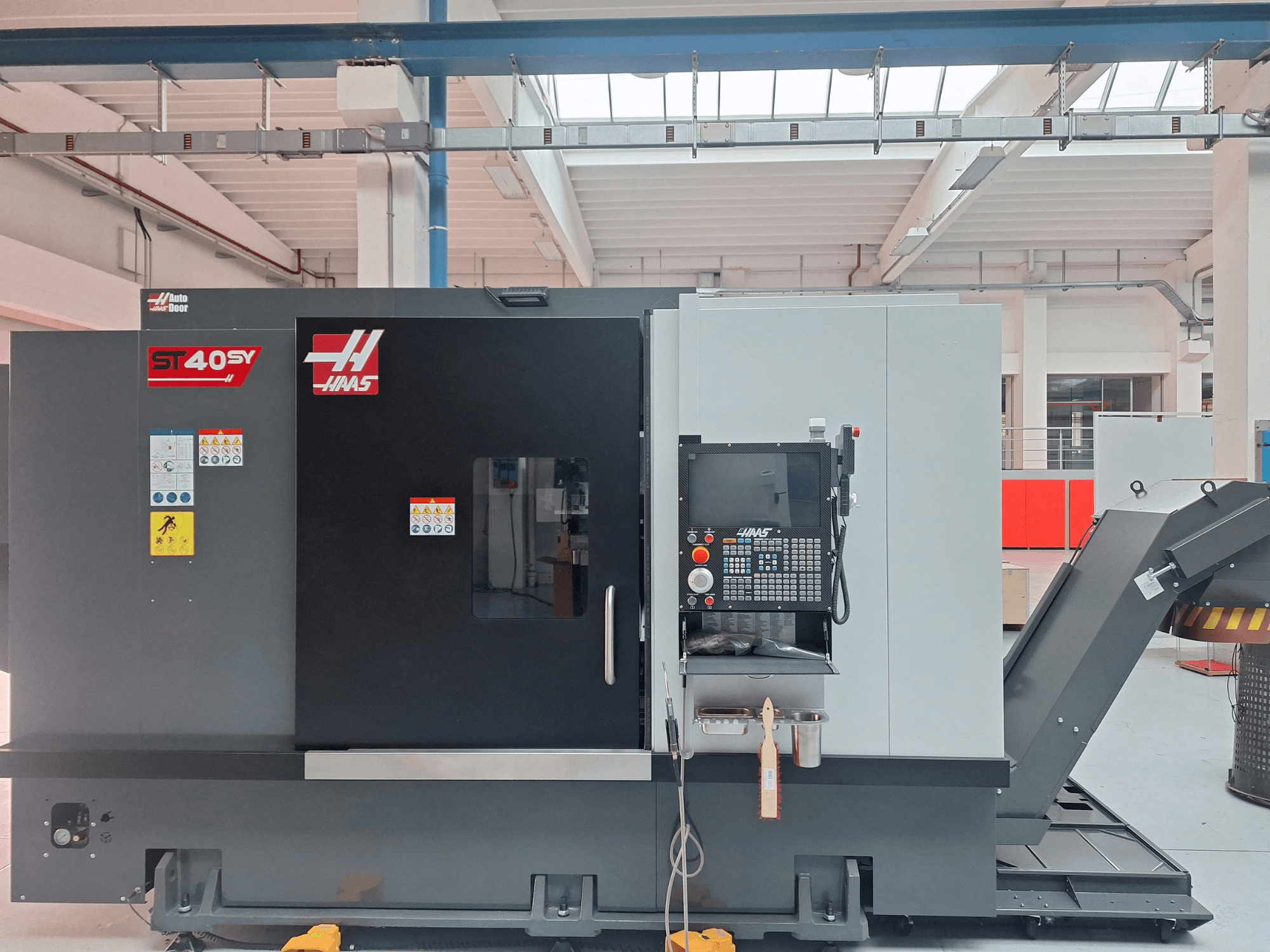 Haas ST-40SY yatay torna tezgahının yandan görünümü; kontrol paneli ve güvenlik etiketleri görülmektedir.