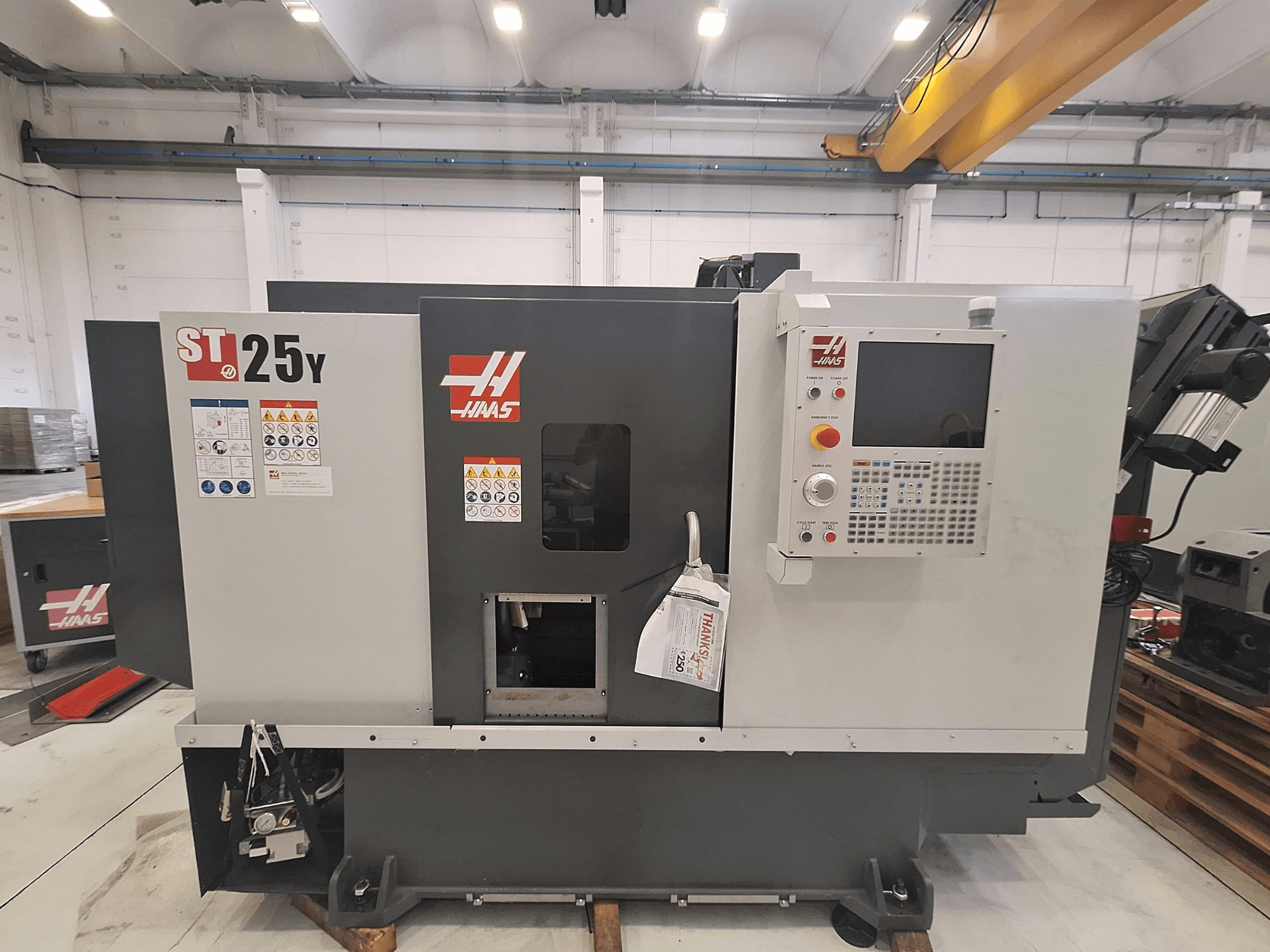 Haas ST-25Y yatay torna tezgahı, önden görünüm; kontrol paneli ve güvenlik etiketleri görülmektedir. Hassas işleme için idealdir.
