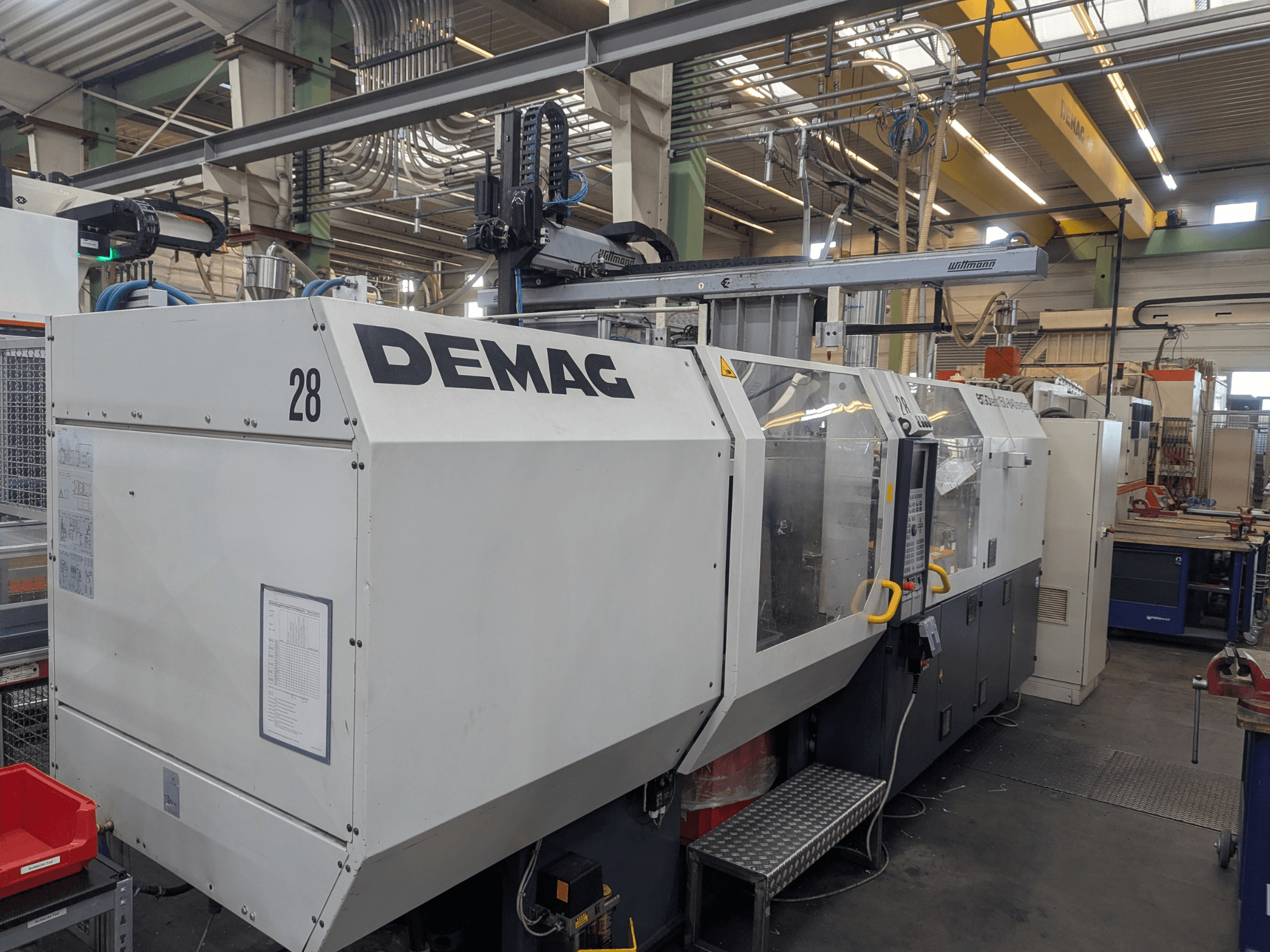 DEMAG ERGOTECH 1500-840 hidrolik enjeksiyon kalıplama makinesinin önden görünümü, operasyonel kontrolleri ve güvenlik özelliklerini sergiliyor.