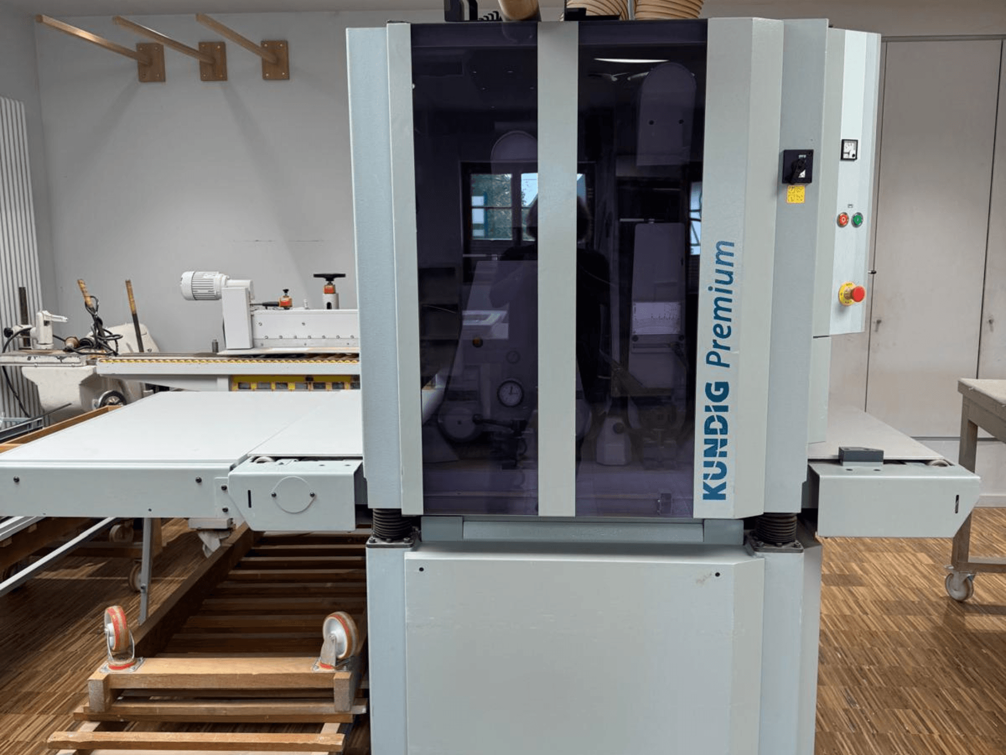 Kundig Premium 2-1100-RP bant zımpara makinesi, kontrol paneli ve görünürlük için büyük cam muhafaza ile önden görünüm.