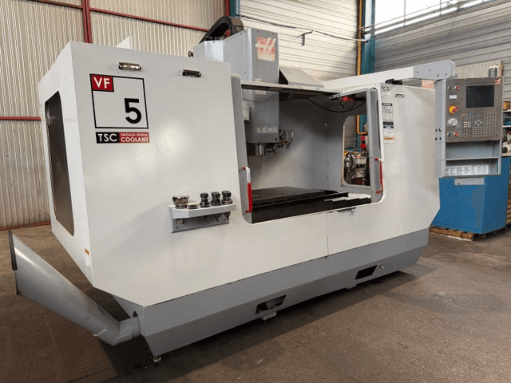 HAAS VF5-HE dikey işleme merkezi, önden görünüm; TSC soğutma sıvısı sistemi ve operatör kontrol paneli gösterilmektedir.
