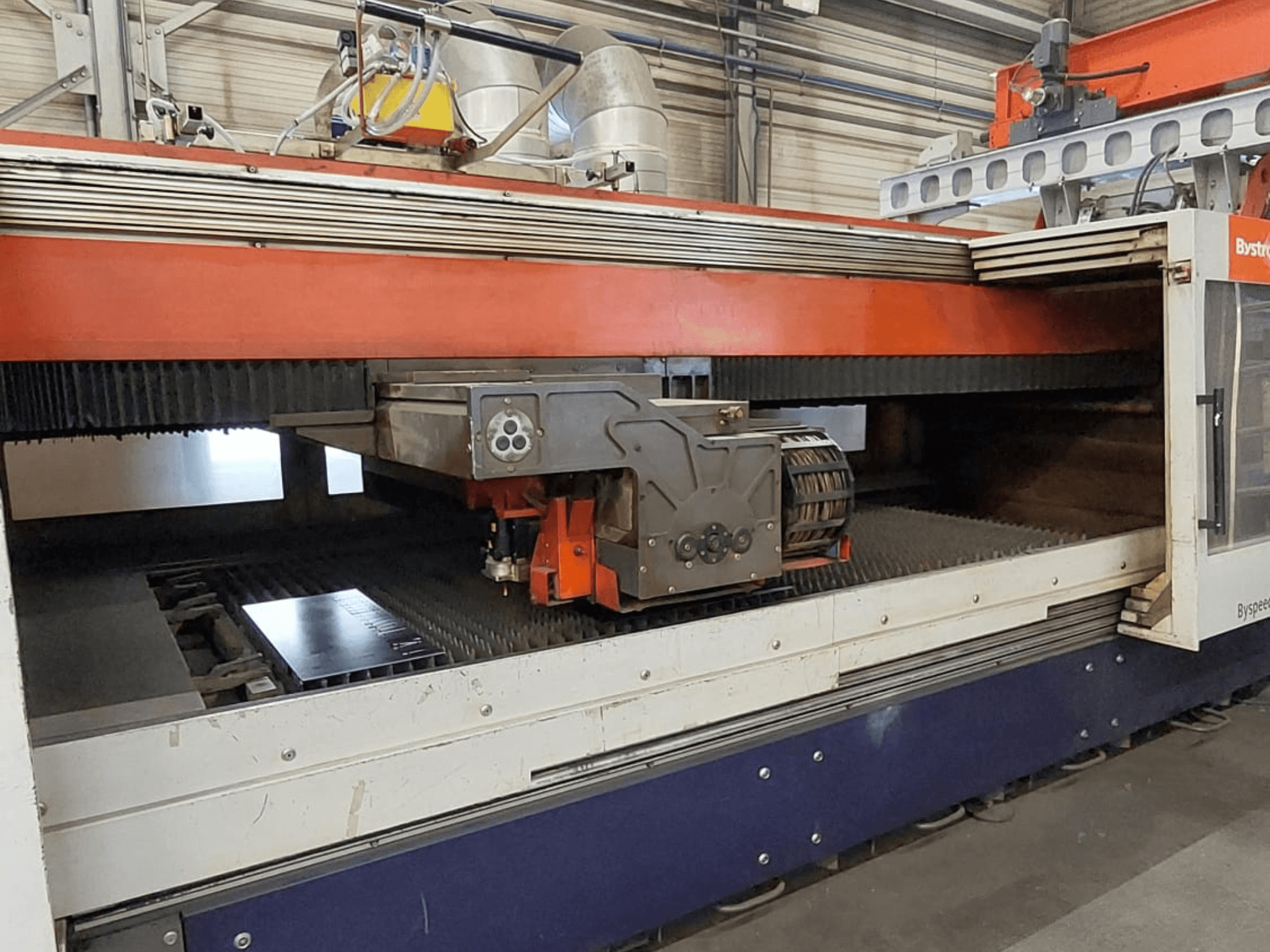 Bystronic BySpeed 3015 CO₂ lazer kesim makinesi; kesim yatağı üzerinde kesim kafası ve metal levhayı gösteren önden görünüm.