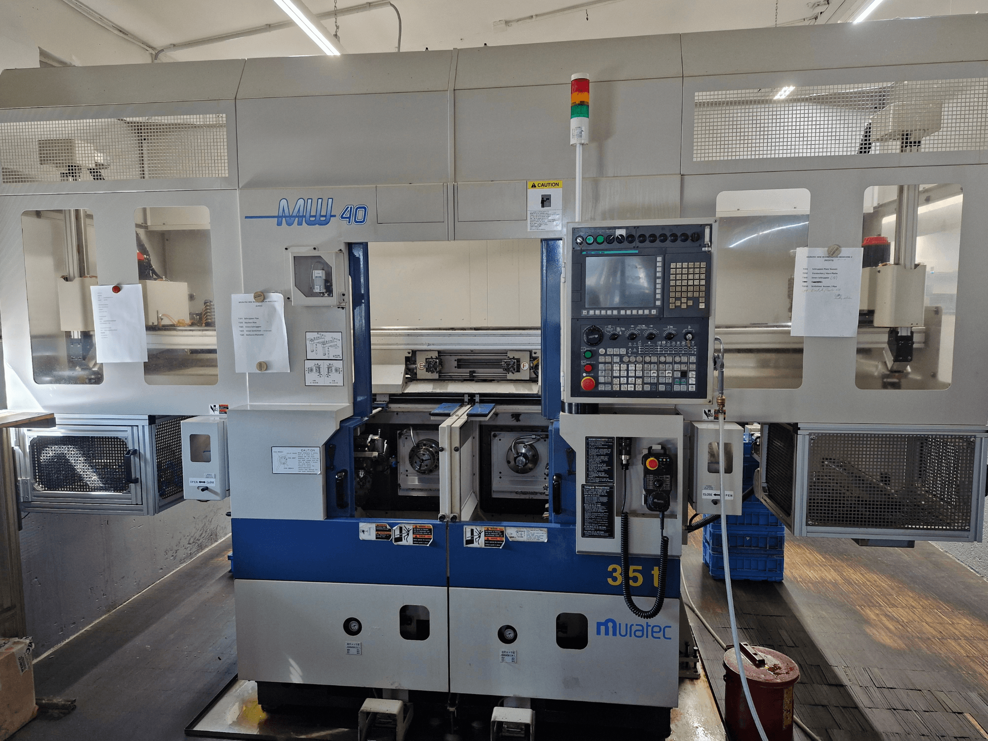 Muratec MW 40 Torna-Freze Merkezi, önden görünüm, kontrol panelini, takım tutucuları ve çalışma detaylarını gösterir.
