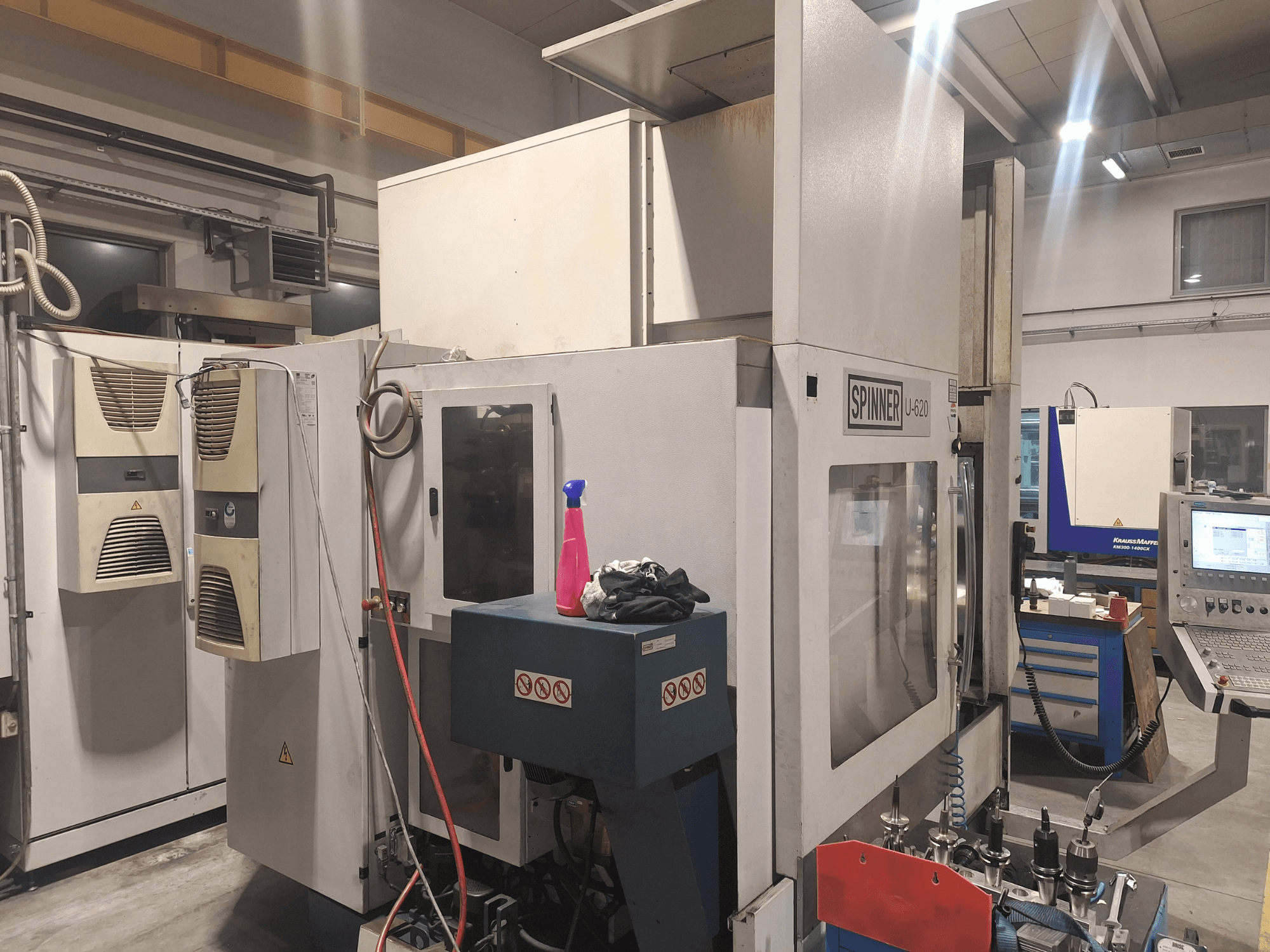 Spinner U-620 CNC makinesi bir atölyede önden gösterilmiştir, kontrol paneli ve yakındaki bir tezgah üzerinde çeşitli aletler bulunmaktadır.