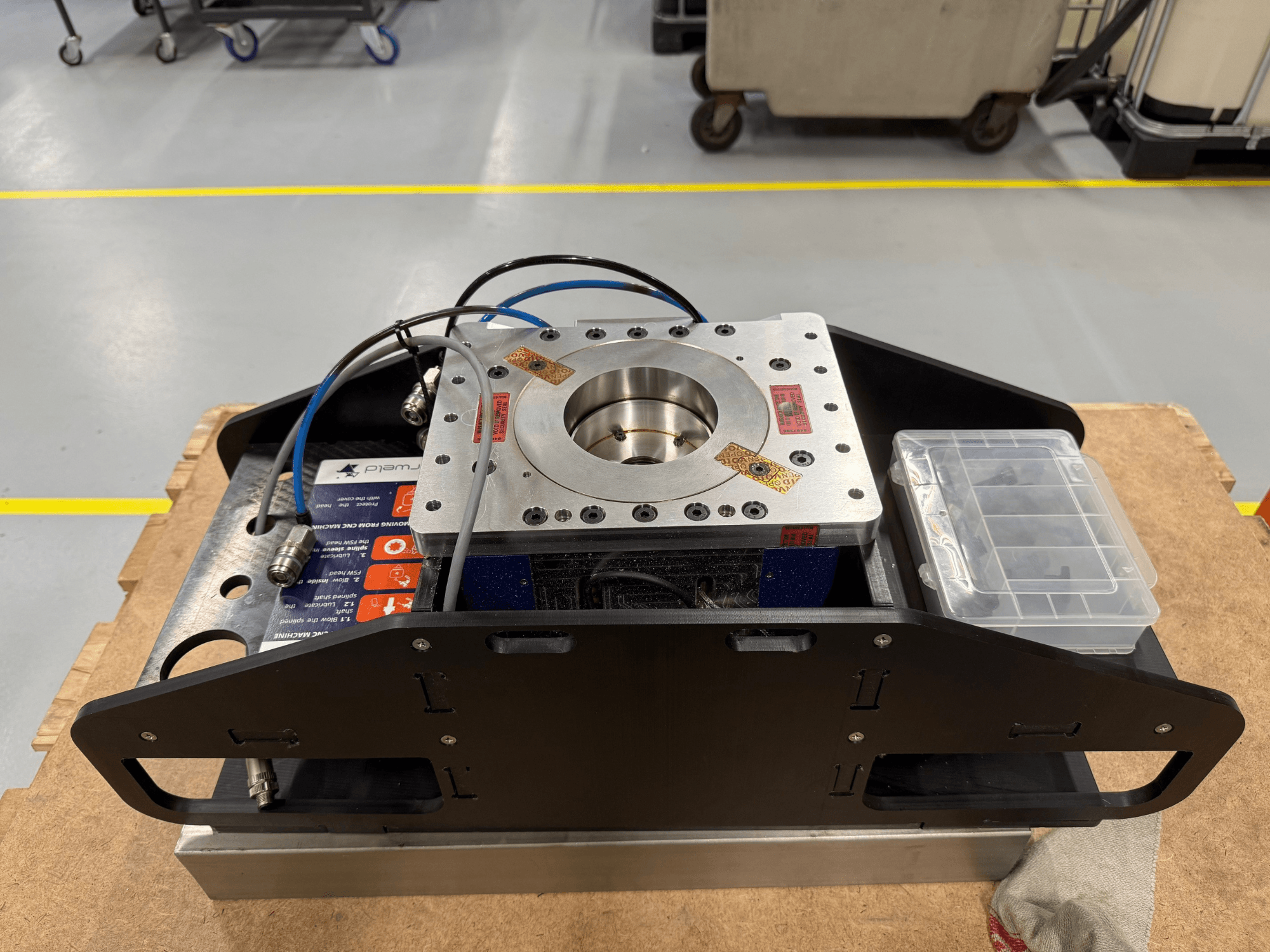 Mavi kabloları, aksesuar kutusu ve düz tabanı ile işlenmiş metal bileşen, üstten görünümlü, mekanik uygulamalar için ideal.