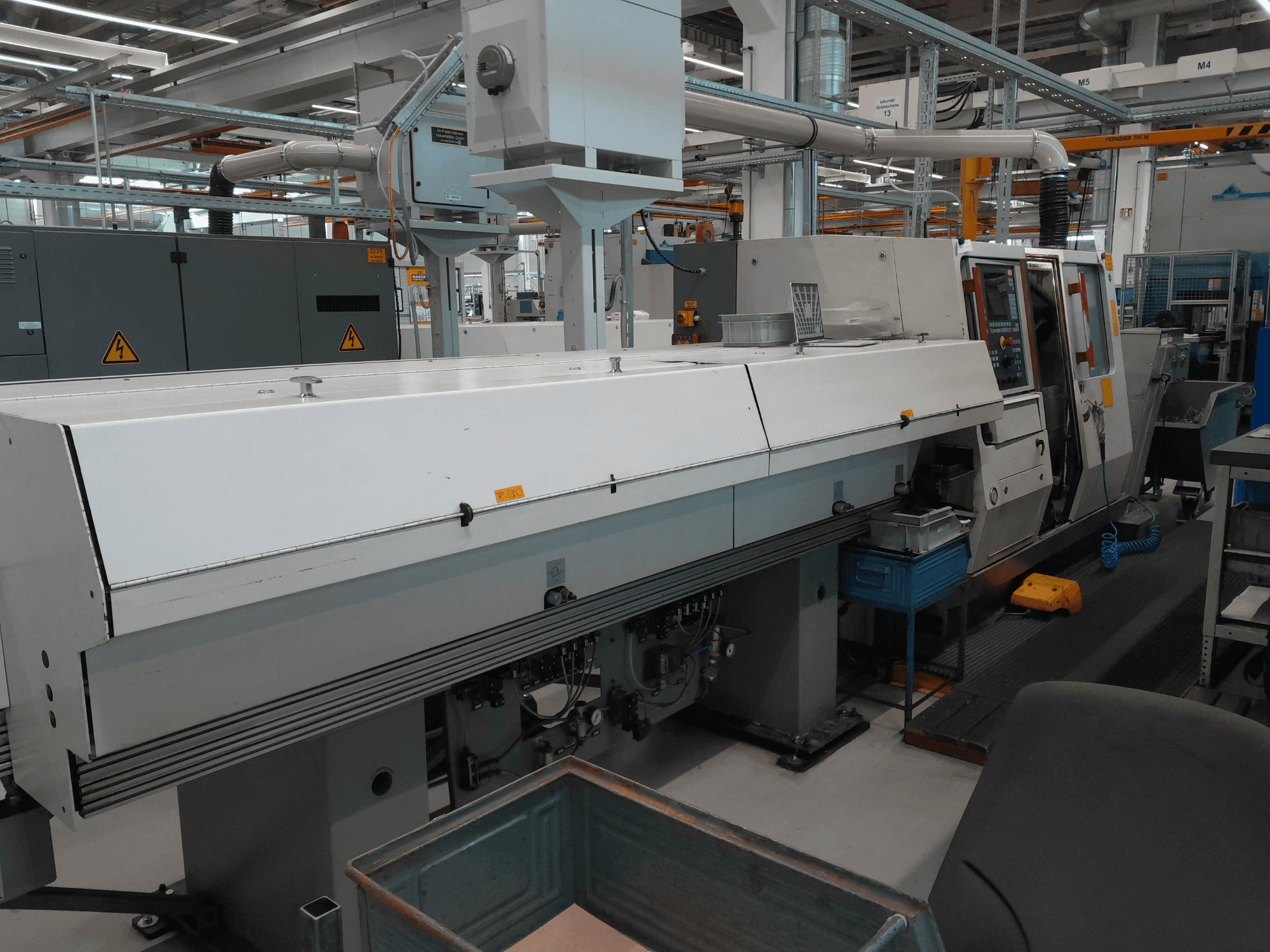 TRAUB TNA 300 yatay torna makinesi, önden görünüm; şık bir tasarıma, kontrol paneline ve operasyonel çalışma alanına sahiptir.