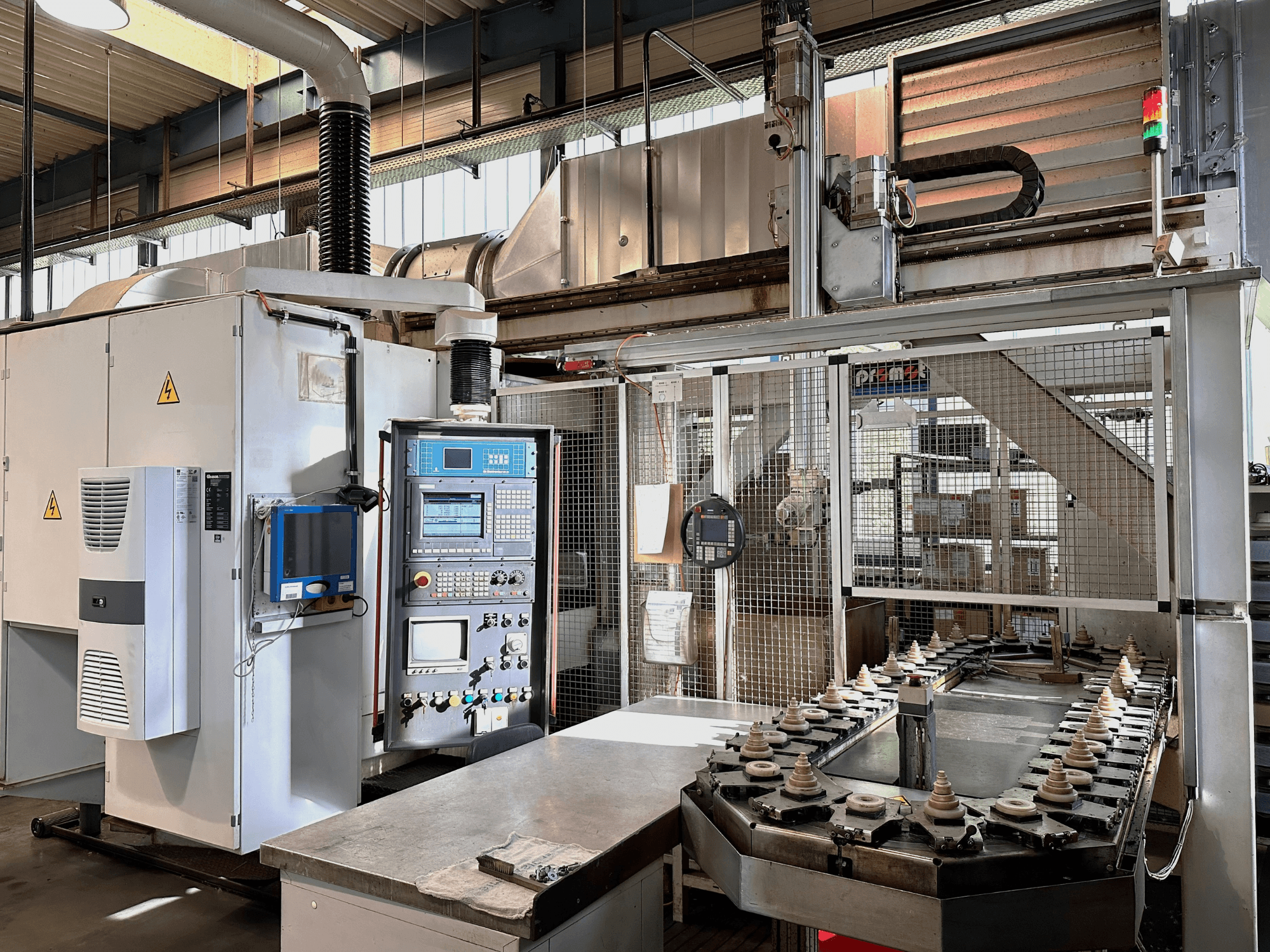 Kontrol paneli, soğutma ünitesi ve konveyör içeren endüstriyel makine. Parlak ışıklar ve güvenlik işaretleri içeren önden görünüm.