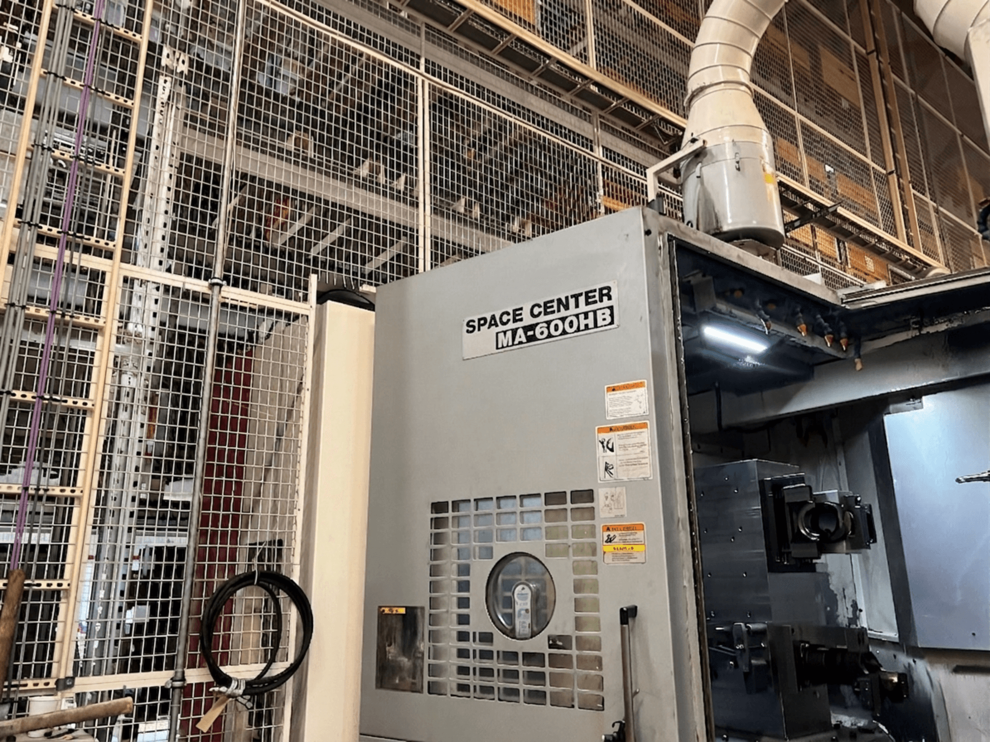 Okuma MA-600HB yatay işleme merkezi, önden görünüm, operasyon paneli ve soğutucu nozulları görünür.