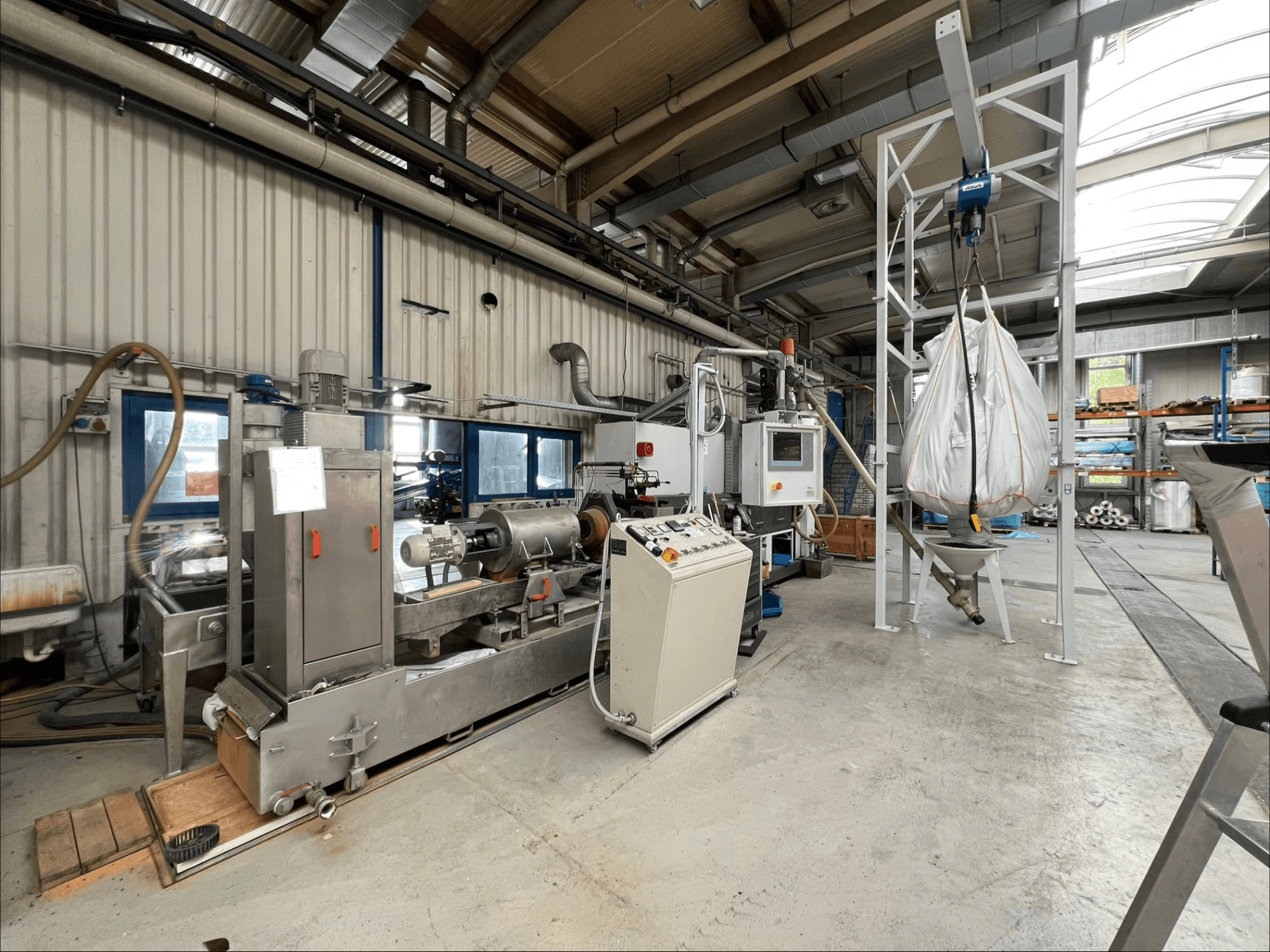 Endüstriyel bir ortamda, kontrol paneli ve besleme sistemi ile birlikte gösterilen FILTEC GRP 350 plastik işleme makinesinin önden görünümü.