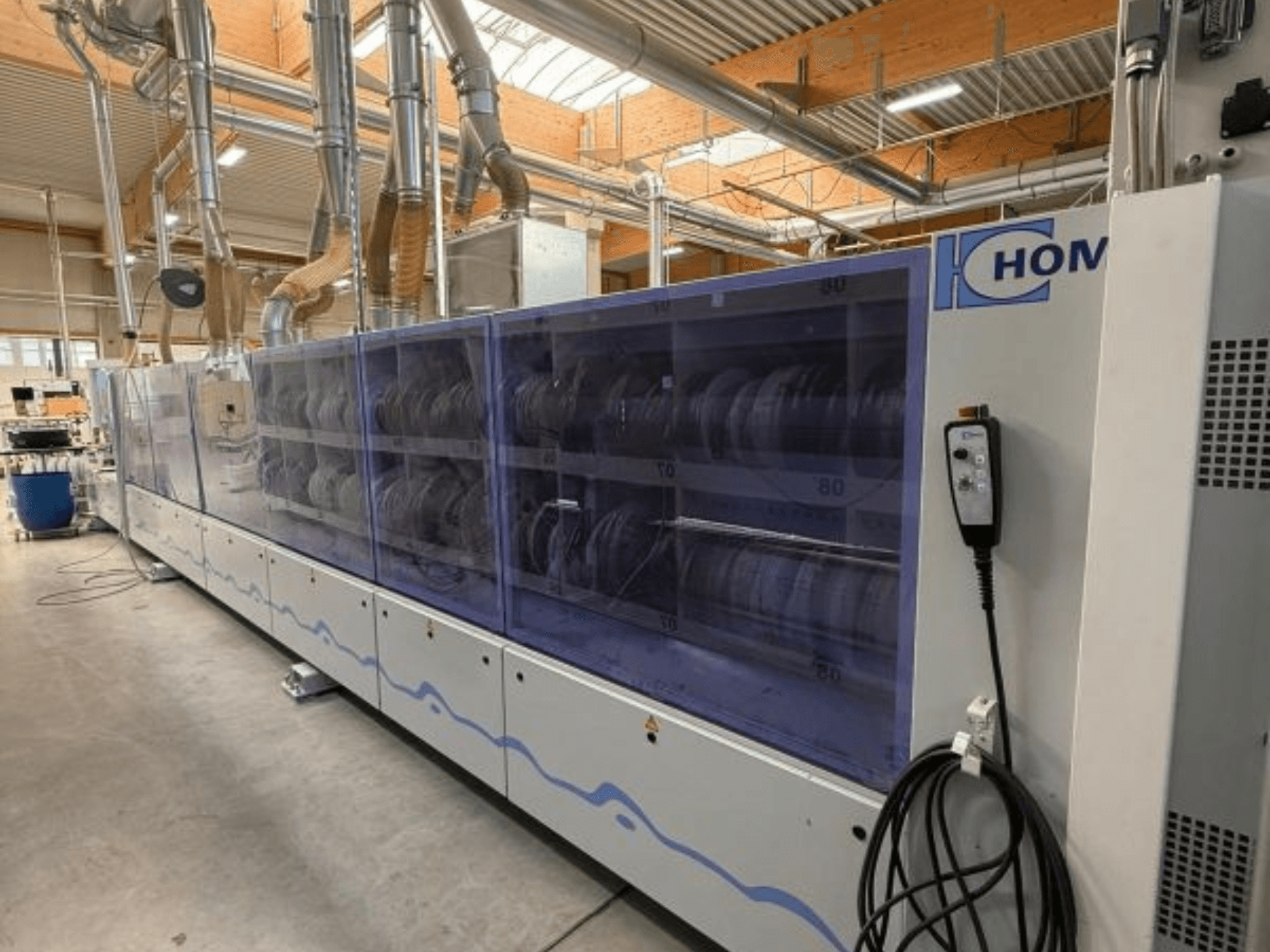 HOM endüstriyel çamaşır makinesi, önden görünüm, bulaşıkları gösteren şeffaf panel; yan tarafta düğmeleri olan kontrol paneli.