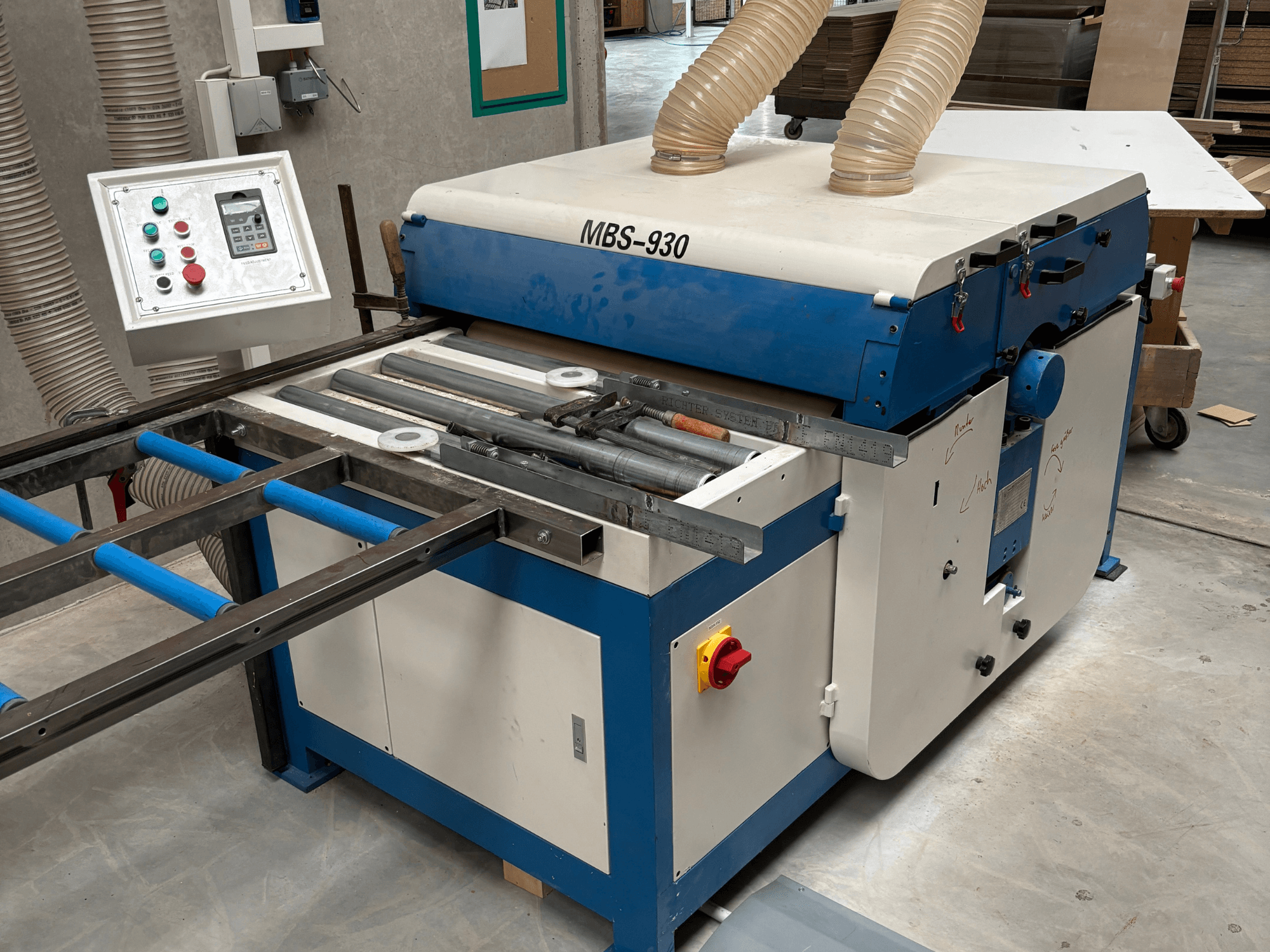 MBS-930 ahşap işleme makinesi, kontrol paneli ve silindirleri ile birlikte, yandan bakıldığında, toz emme hortumlarına sahiptir.