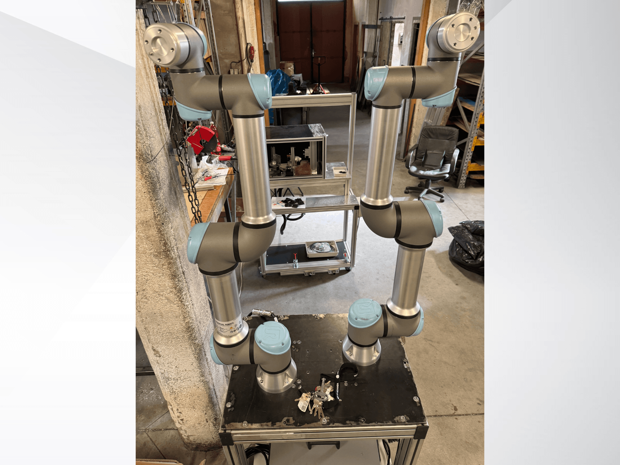 Universal Robots UR5e robot kolu, siyah bir platform üzerine monte edilmiş, gri ve mavi bölümlere sahip altı eklemli, önden görünümlüdür.