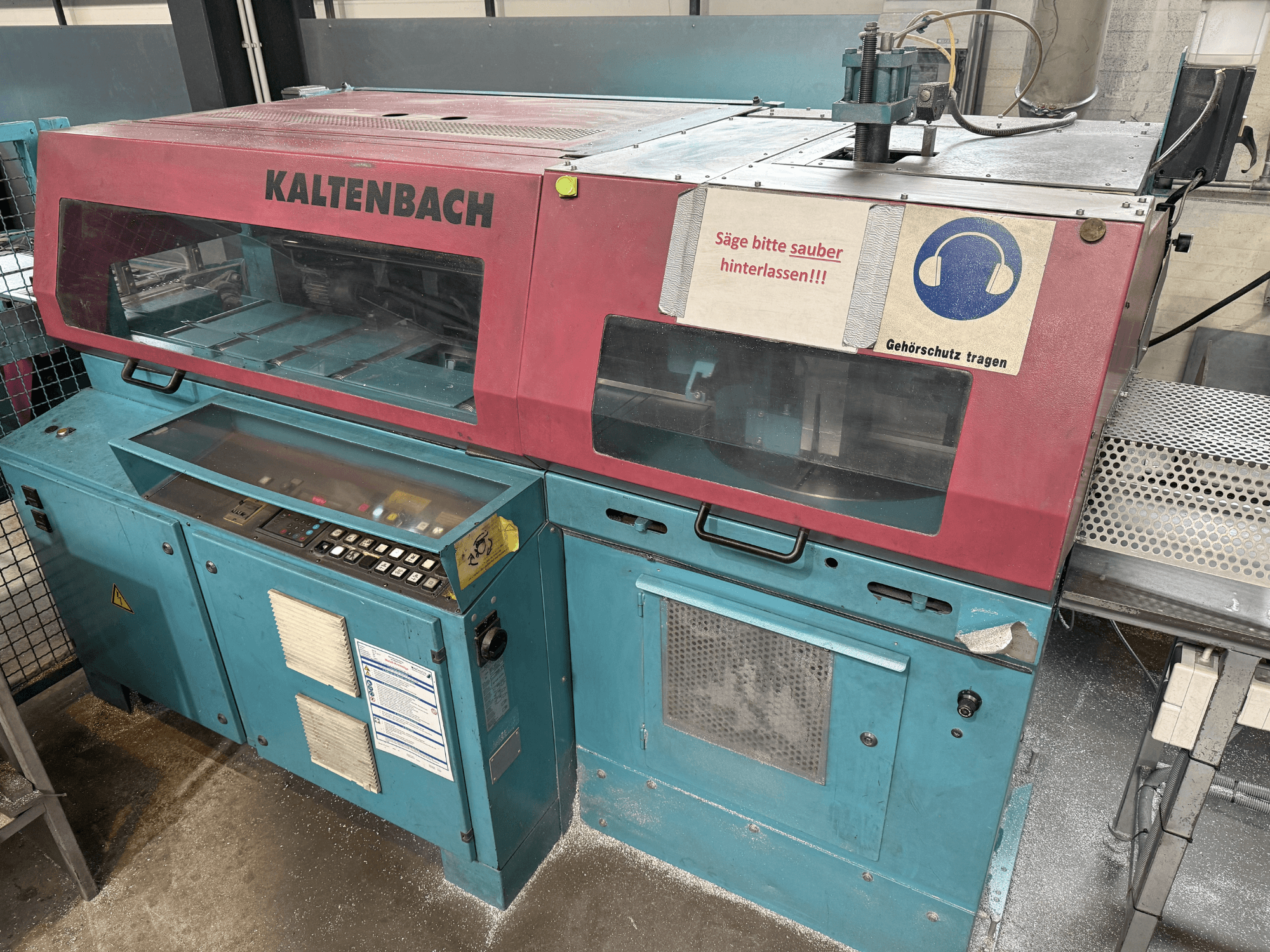 KALTENBACH endüstriyel kesim makinesi, önden görünüm, kontrol paneli ve işitme koruması için güvenlik işareti.